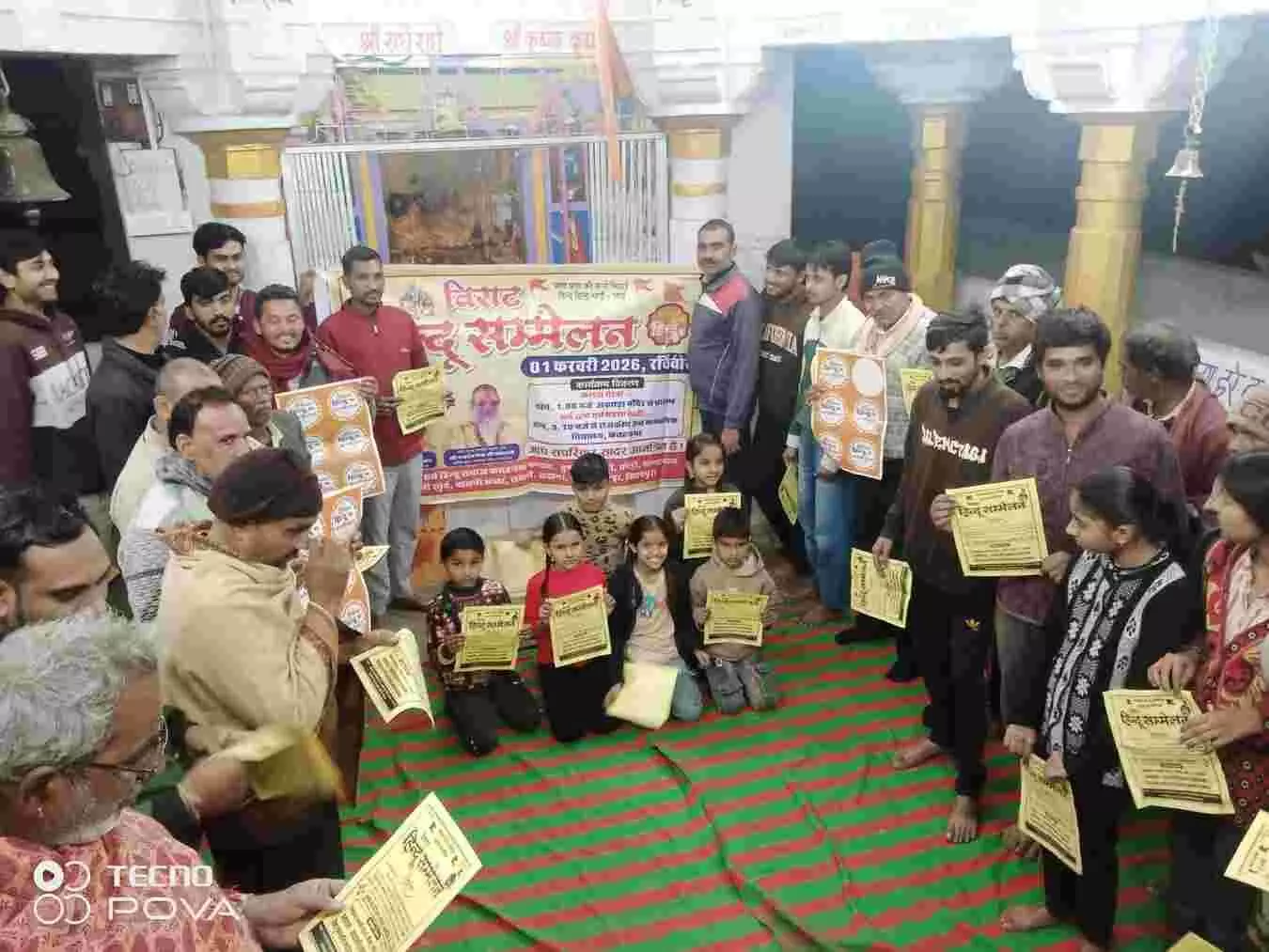 लदानी के चारभुजा मंदिर में हिन्दू सम्मेलन का आमंत्रण पत्र दिखाते ग्रामीण और समाजजन।