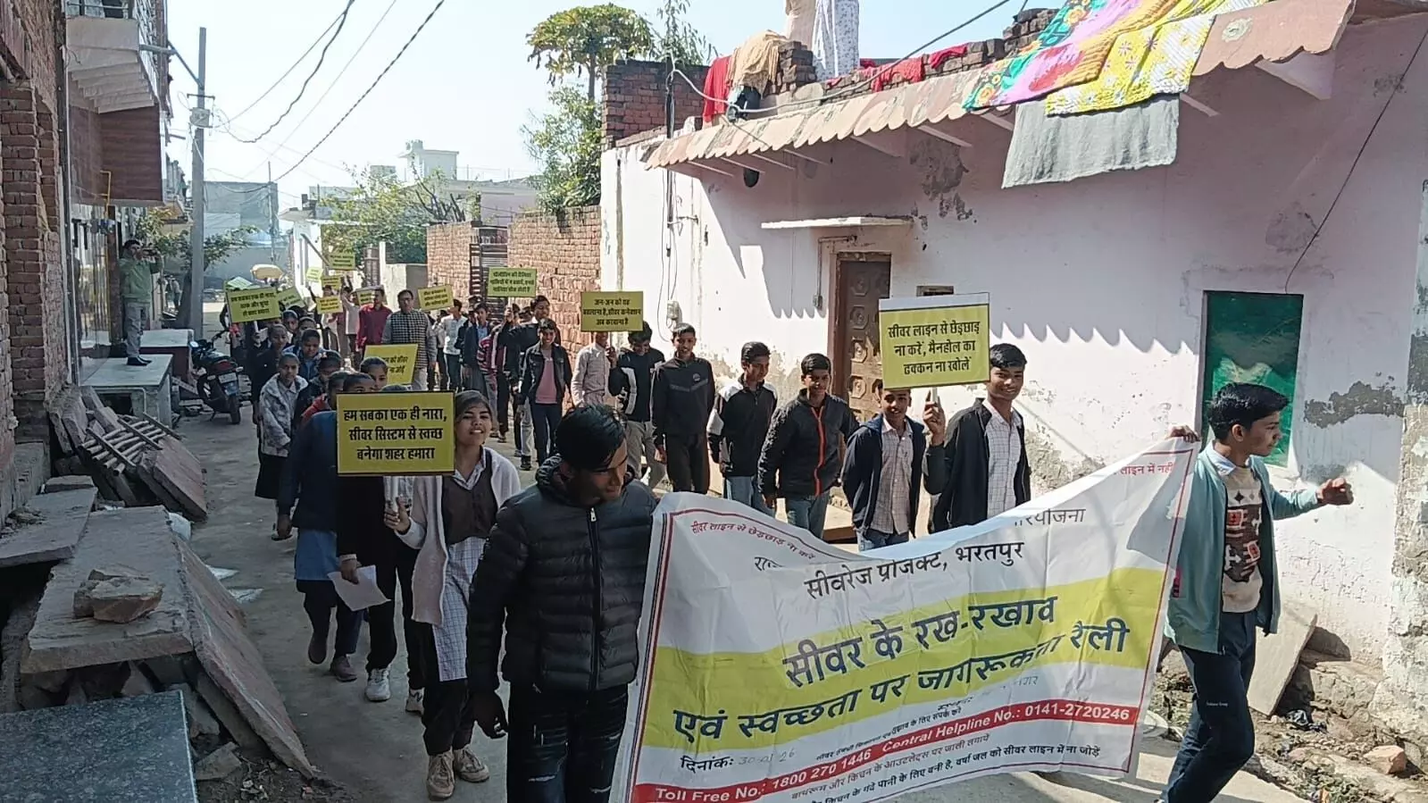 भरतपुर के आनंद नगर में छात्र जागरूकता नारों की तख्तियां लेकर स्वच्छता रैली निकालते हुए।