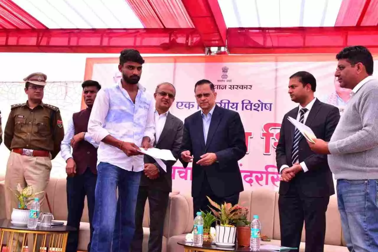 मुख्य सचिव वी श्रीनिवास बांदरसिंदरी ग्राम उत्थान शिविर में लाभार्थियों को सहायता राशि के चेक सौंपते हुए।