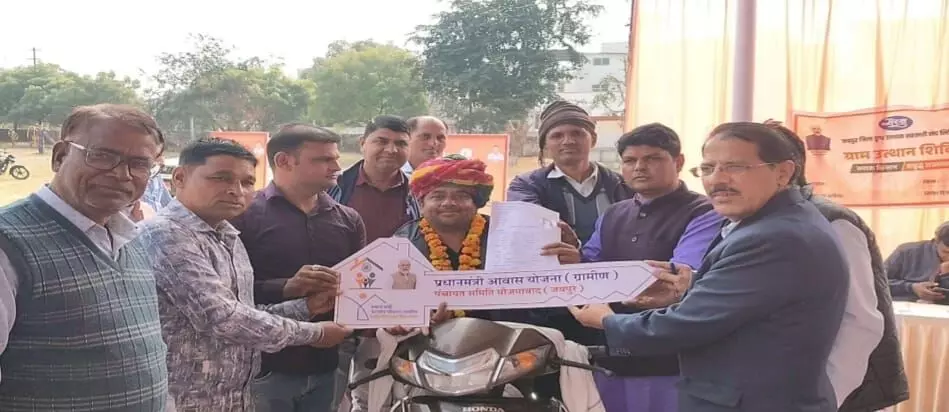 बोराज ग्राम पंचायत के शिविर में उपखंड अधिकारी लाभार्थी को प्रधानमंत्री आवास योजना के पक्के घर की चाबी देते हुए।