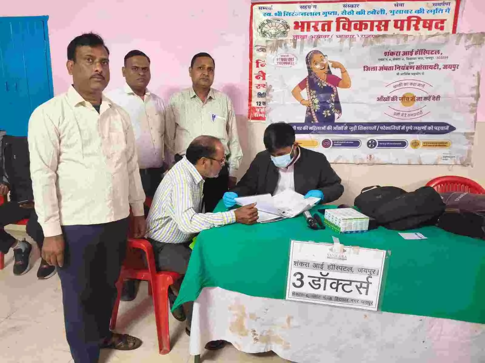 राधाकृष्ण धर्मशाला भुसावर में डॉक्टर द्वारा मरीजों की आंखों की जांच करते हुए दृश्य।