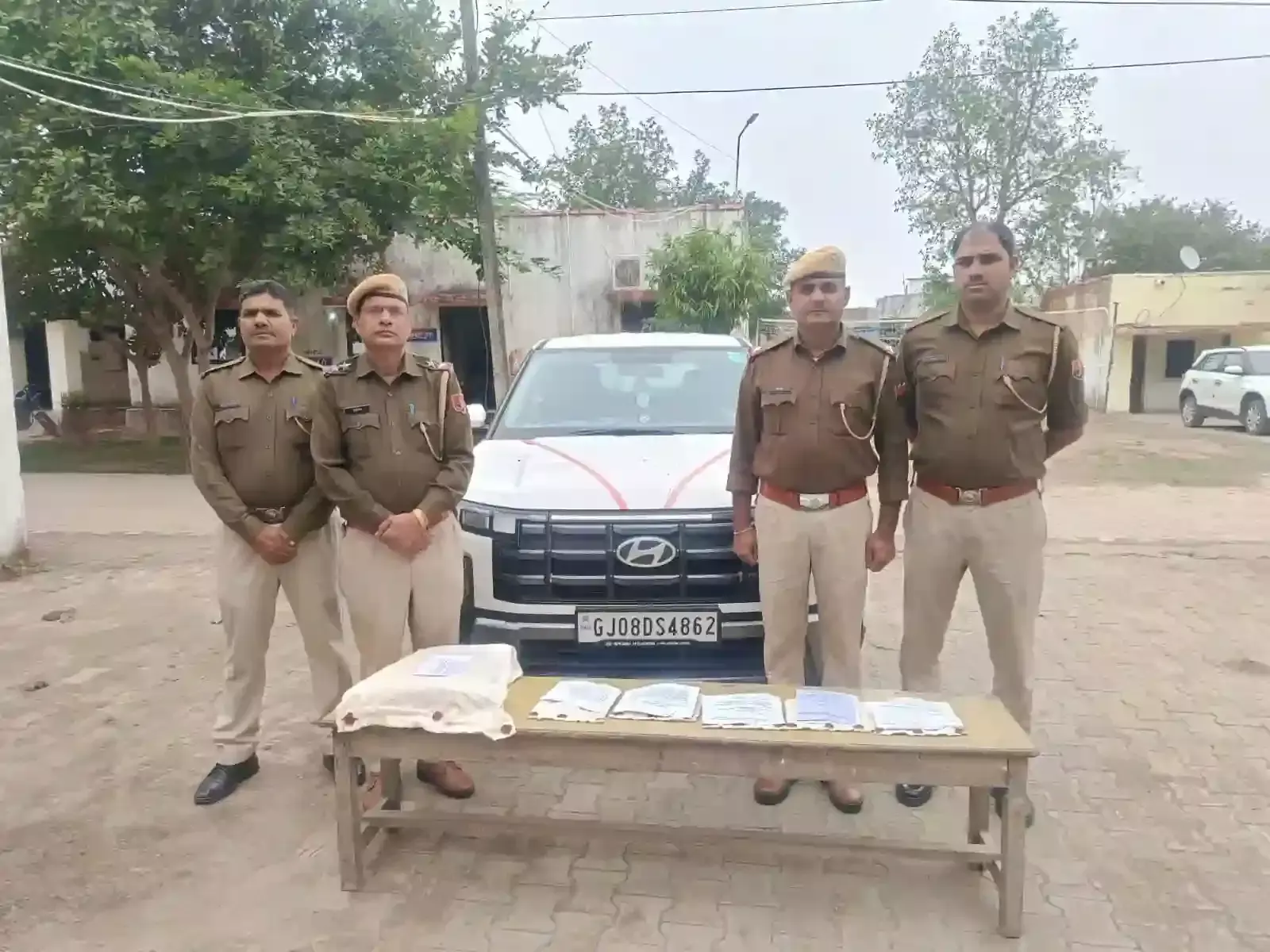 झालावाड़ के सारोला कलां में पुलिस टीम के साथ खड़े गिरफ्तार तीन आरोपी और जब्त लग्जरी कार।