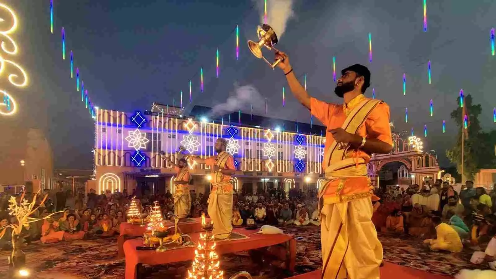 हरिशेवा धाम भीलवाड़ा में जल और दीपों से गंगा आरती करते पंडित और उपस्थित श्रद्धालु।