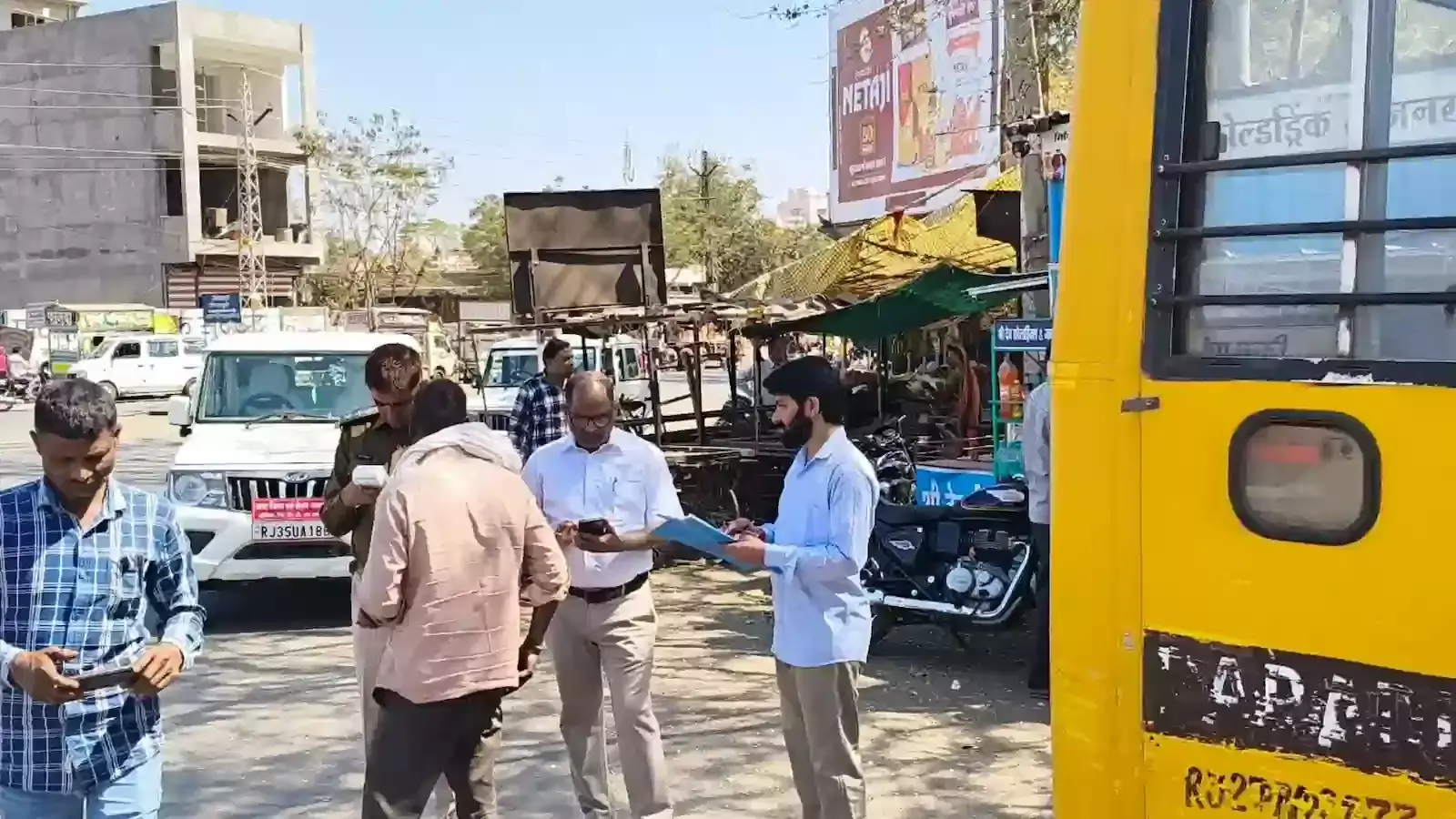 धरियावद नाके पर अधिकारियों द्वारा स्कूली बस के दस्तावेजों और सुरक्षा मानकों की भौतिक जांच का दृश्य। धरियावद नाके पर अधिकारियों द्वारा स्कूली बस के दस्तावेजों और सुरक्षा मानकों की भौतिक जांच का दृश्य।