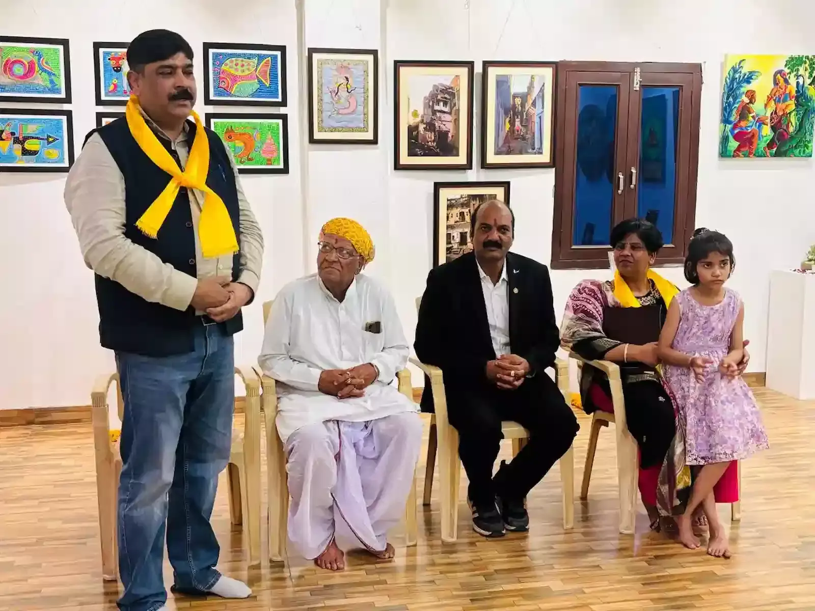 भीलवाड़ा में महिला चित्र प्रदर्शनी के दौरान दीवार पर सजी पेंटिंग्स को देखते हुए लोग।