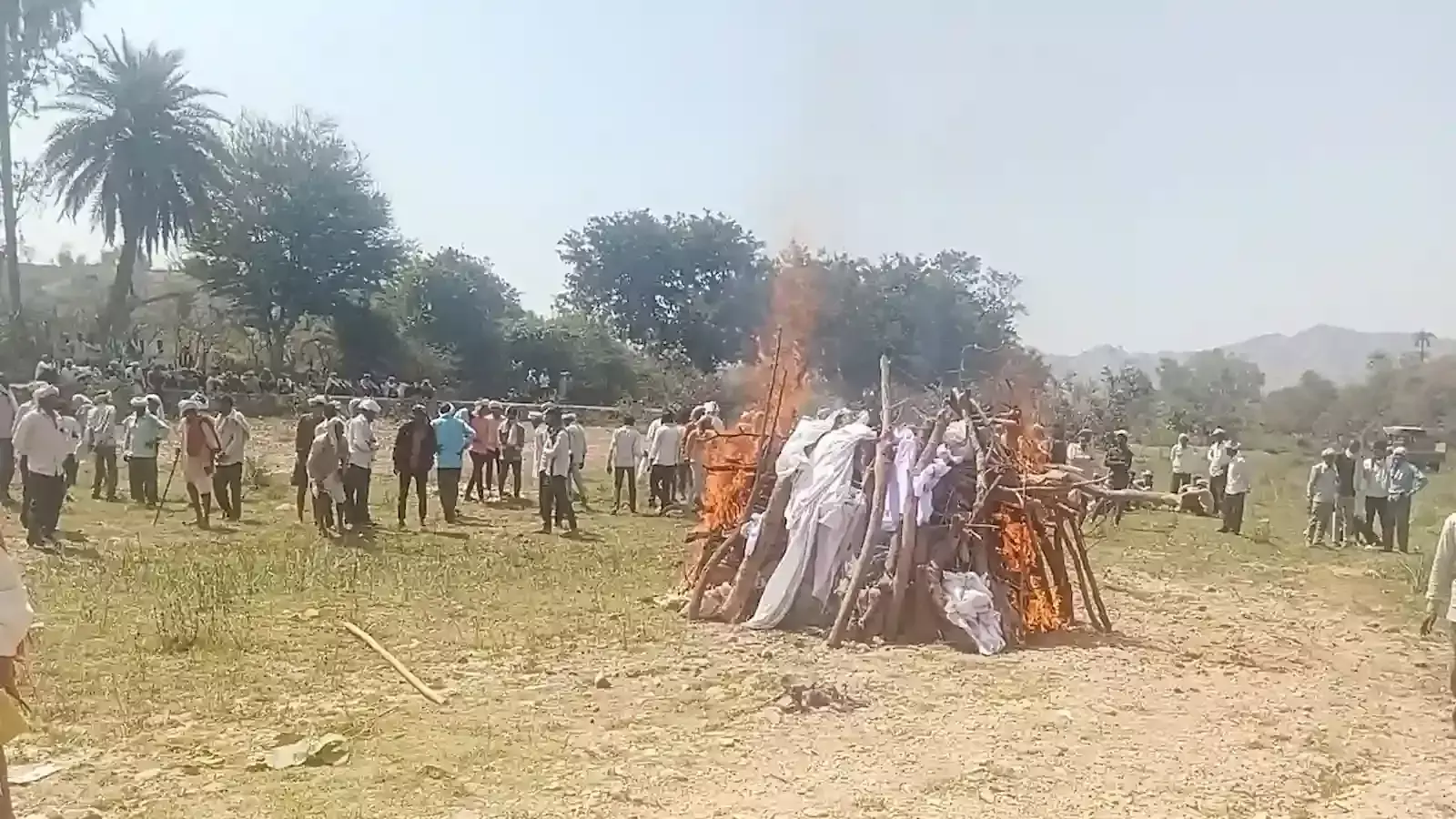उदयपुर के फलासिया में नदी के पेटे में ग्रामीण बुजुर्ग का अंतिम संस्कार करते हुए।