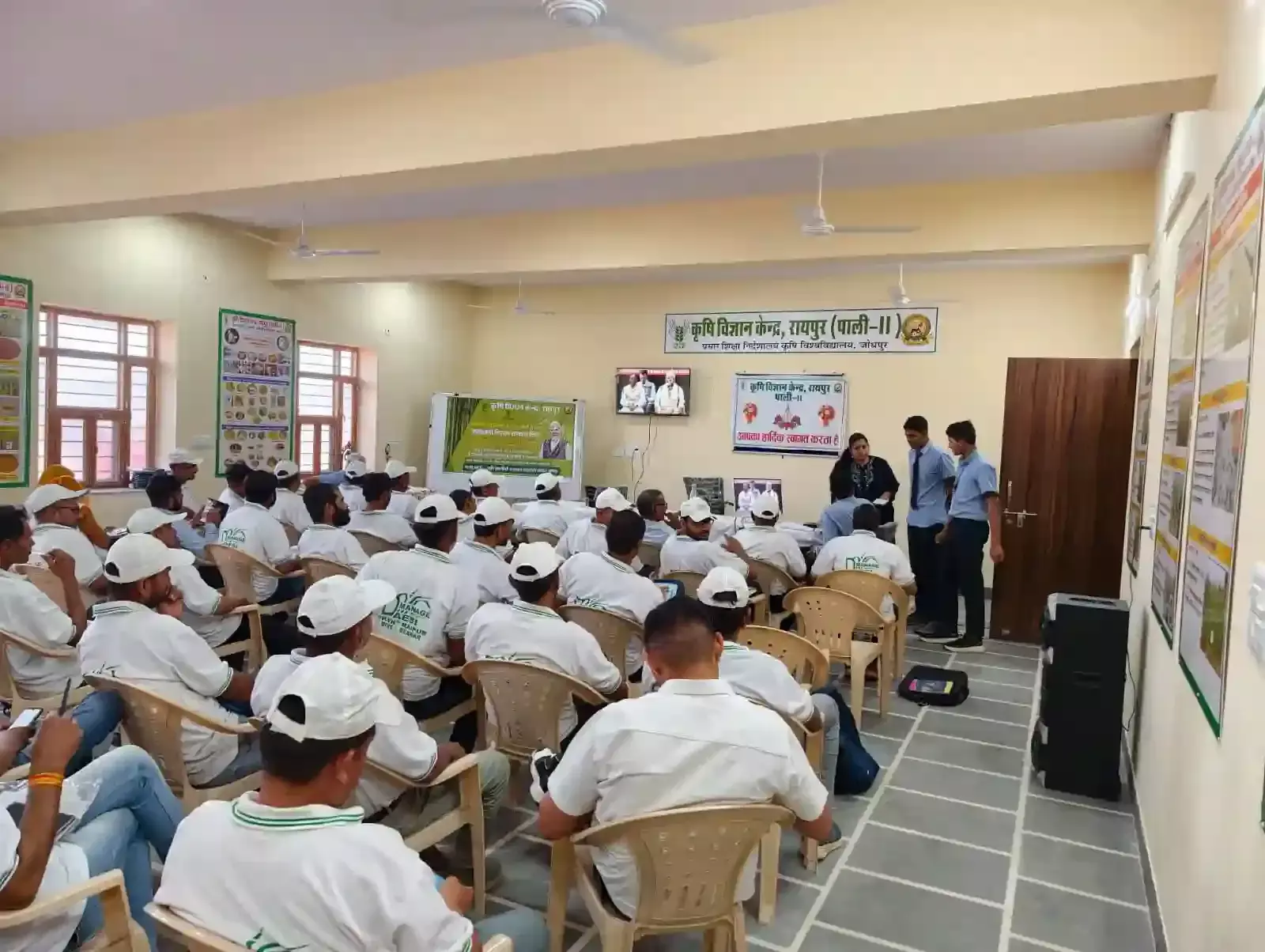 कृषि विज्ञान केंद्र रायपुर में किसान और ग्रामीण टीवी स्क्रीन पर प्रधानमंत्री किसान सम्मान निधि योजना का सजीव प्रसारण देख रहे हैं।