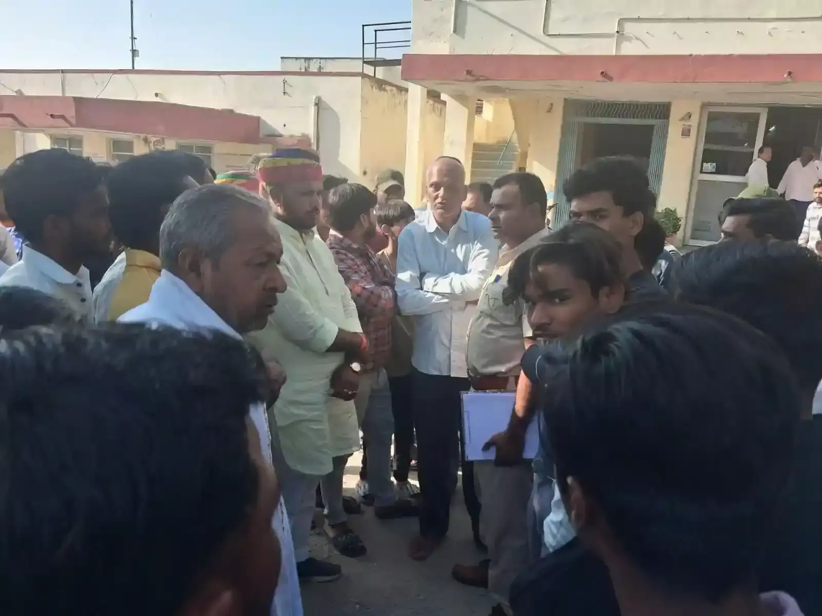 लसाड़िया सामुदायिक स्वास्थ्य केंद्र के बाहर खड़े लोग और पुलिसकर्मी सड़क दुर्घटना जांच के संदर्भ में।