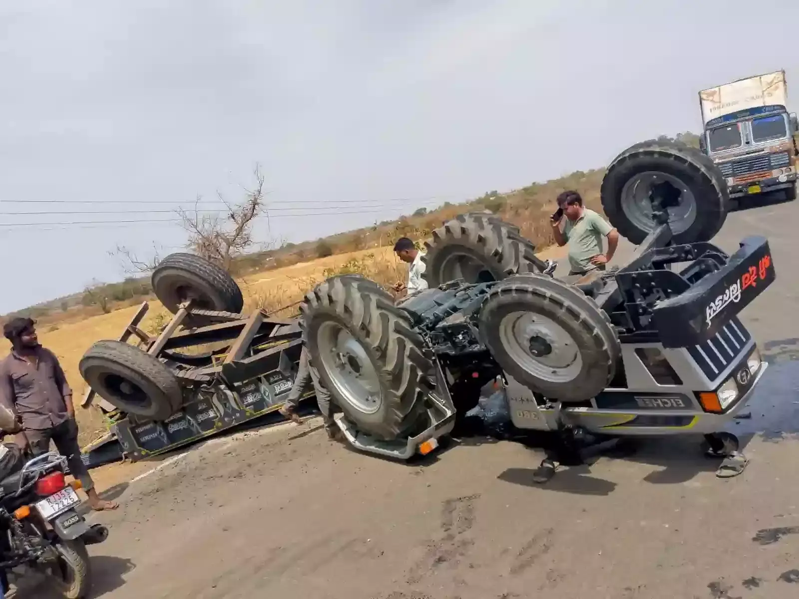 छोटीसादड़ी नीमच स्टेट हाईवे पर पलटी हुई ट्रैक्टर ट्रॉली और बिखरी हुई लोहे की सलियों का दृश्य।