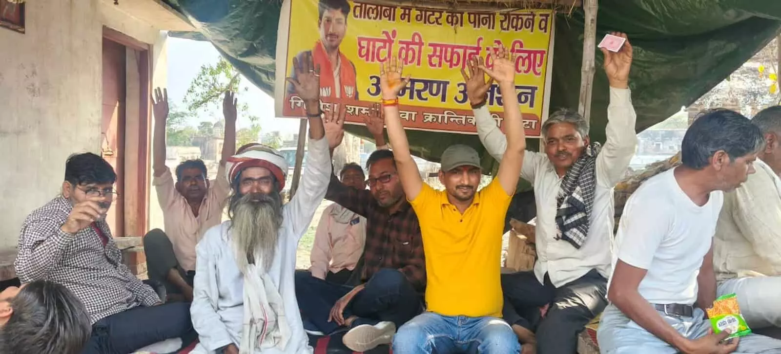 डीग में जलमहल के पास तालाब किनारे गंदगी के विरुद्ध धरना देते प्रदर्शनकारी युवा।