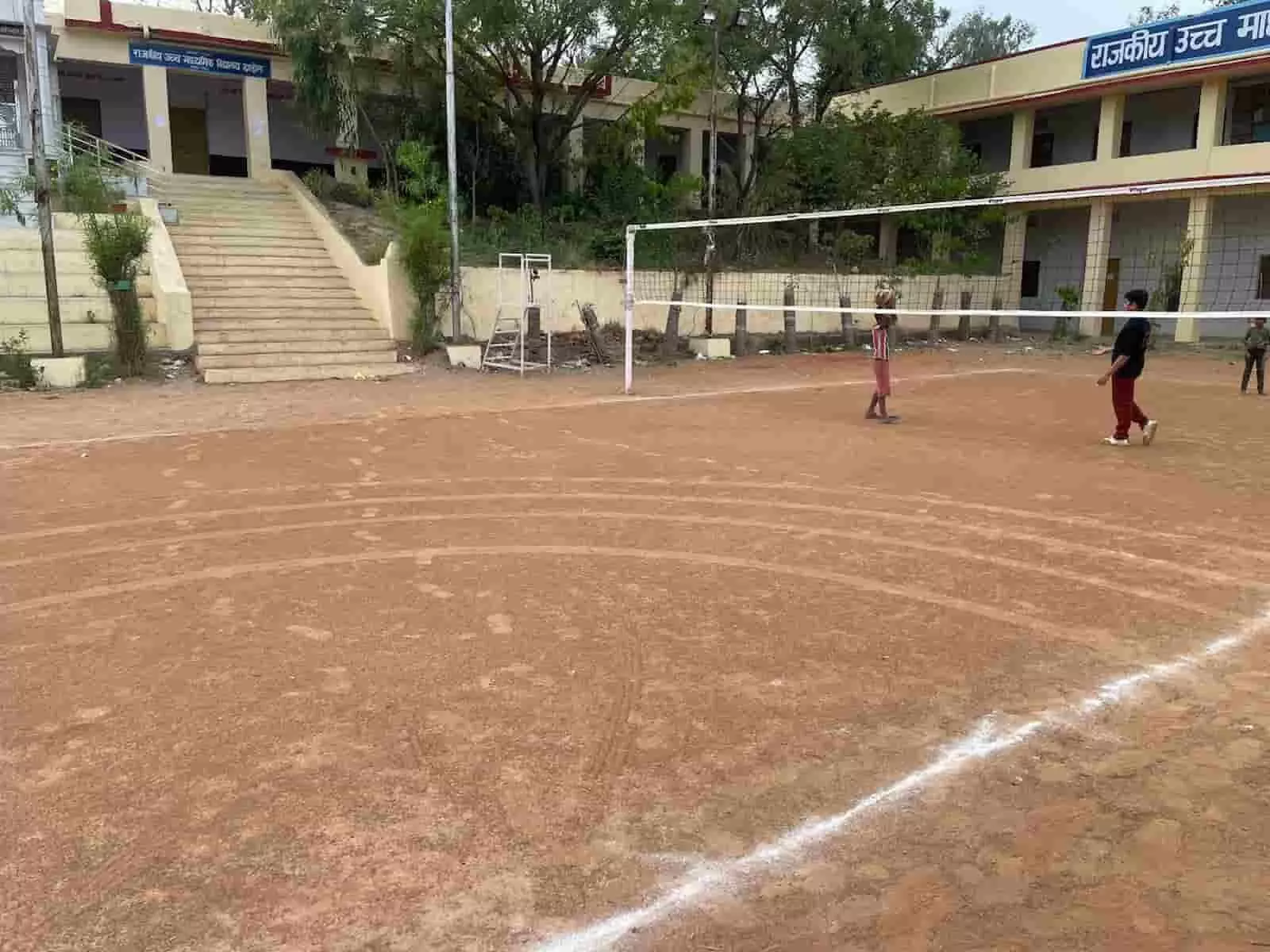उदयपुर के झाड़ोल स्थित सीनियर स्कूल के खेल मैदान में वाहनों के टायरों से बने गहरे गड्ढे और खराब हुआ वॉलीबॉल कोर्ट।