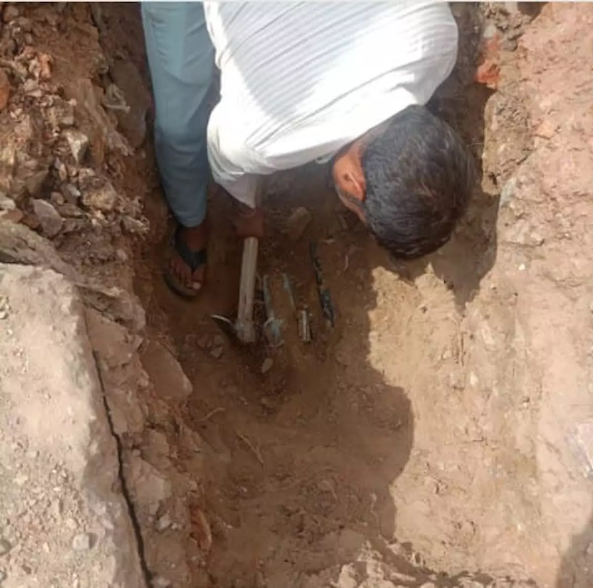 डीग के ग्राम परमदरा में पाइपलाइन से अवैध जल कनेक्शन हटाते विभाग के कर्मचारी।