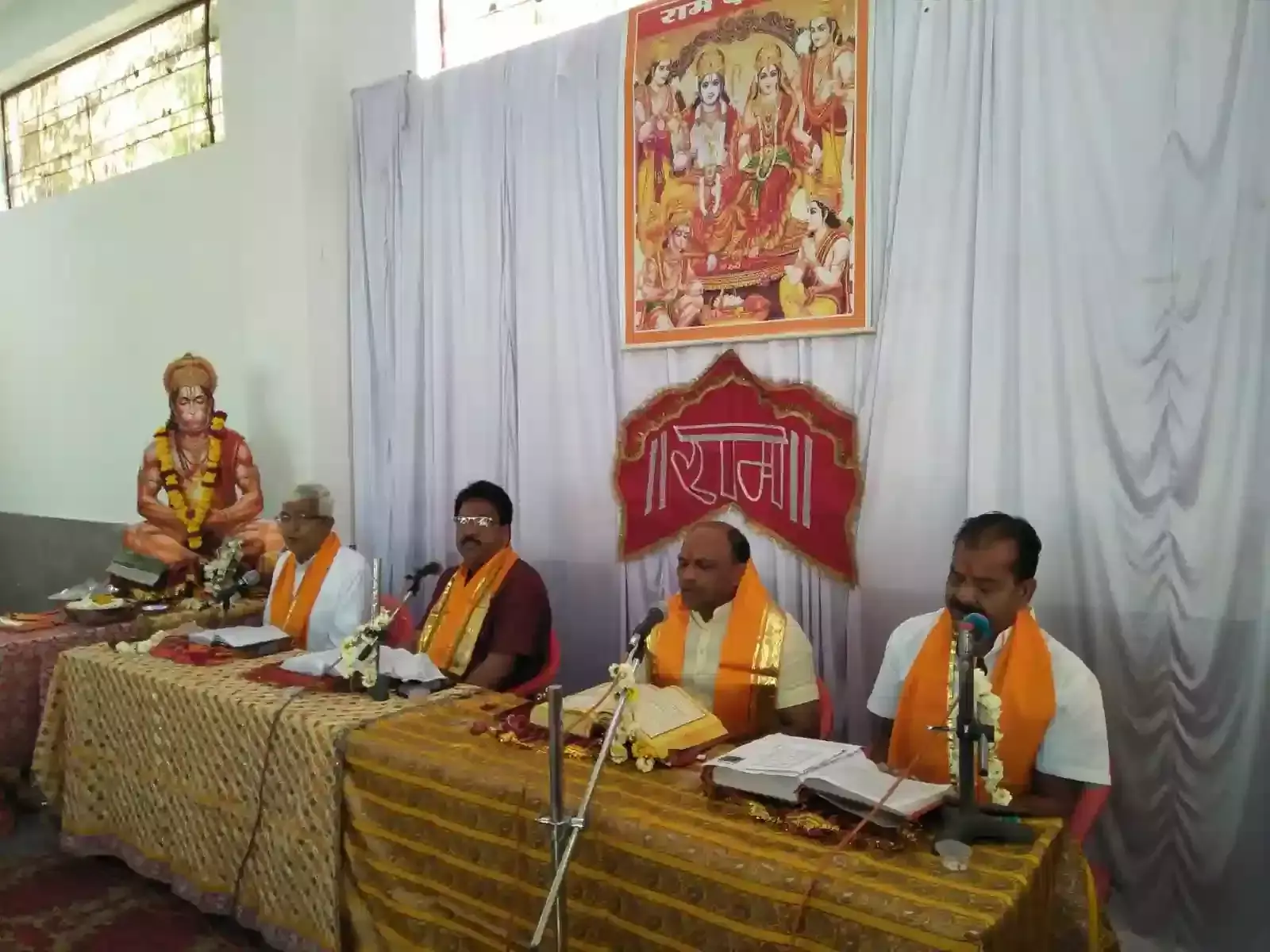 फतहनगर के श्री मनोकामना सिद्ध हनुमान मंदिर में सामूहिक नवाह्नपारायण रामायण पाठ करते हुए पुरुष और महिला श्रद्धालु।