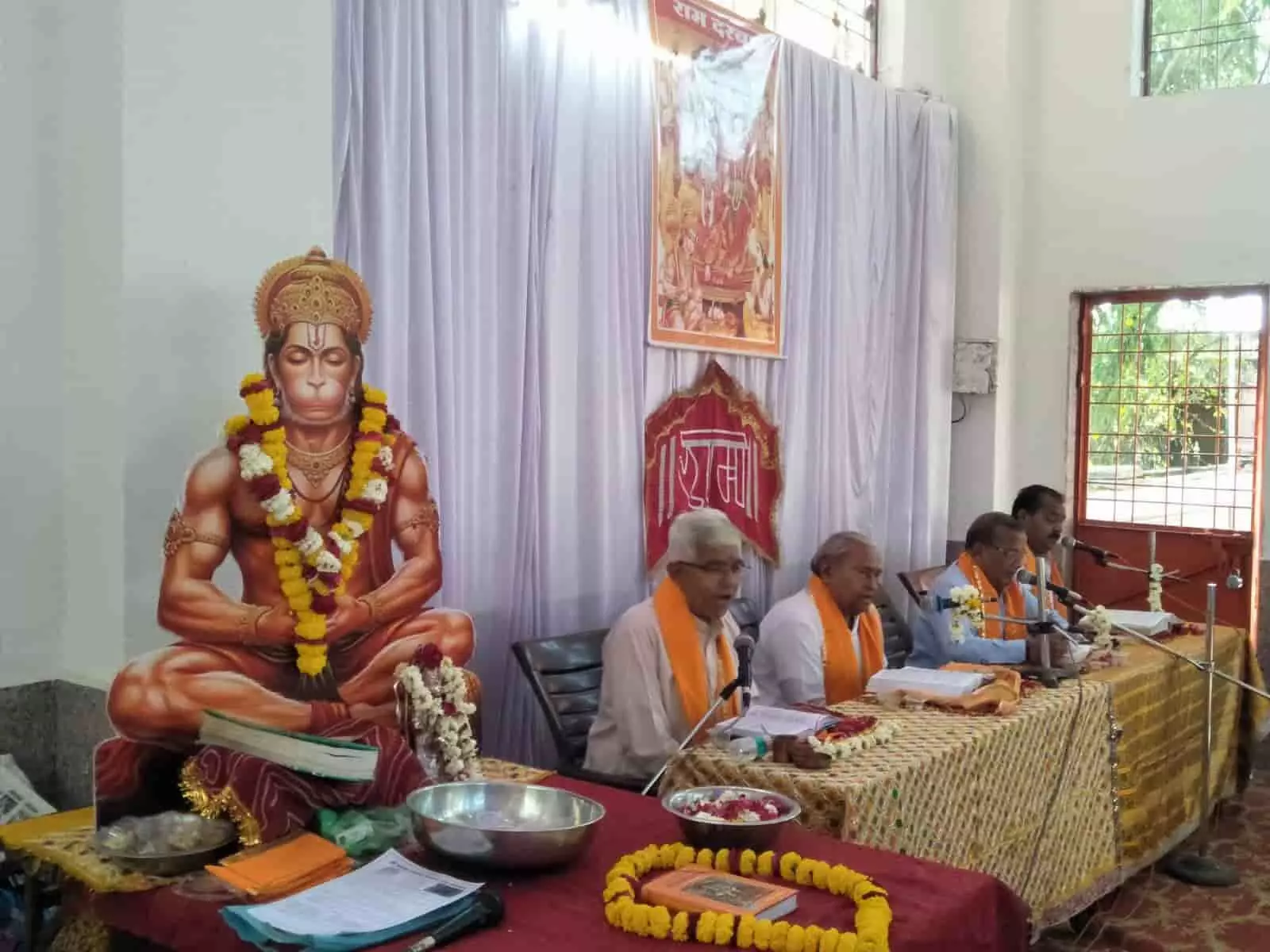 फतहनगर के हनुमान मंदिर में सामूहिक रामायण पाठ करते हुए श्रद्धालु और मुख्य व्यासपीठ पर आसीन अतिथि।