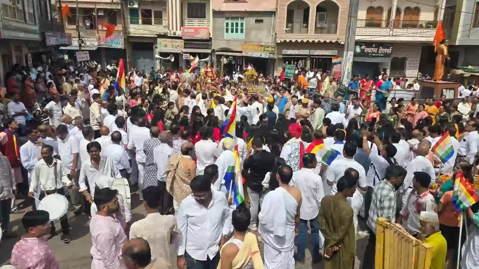 महावीर जन्मकल्याणक के वरघोड़े में भगवान की पालकी उठाकर चलते श्रद्धालु और भजन गाती महिलाएं।