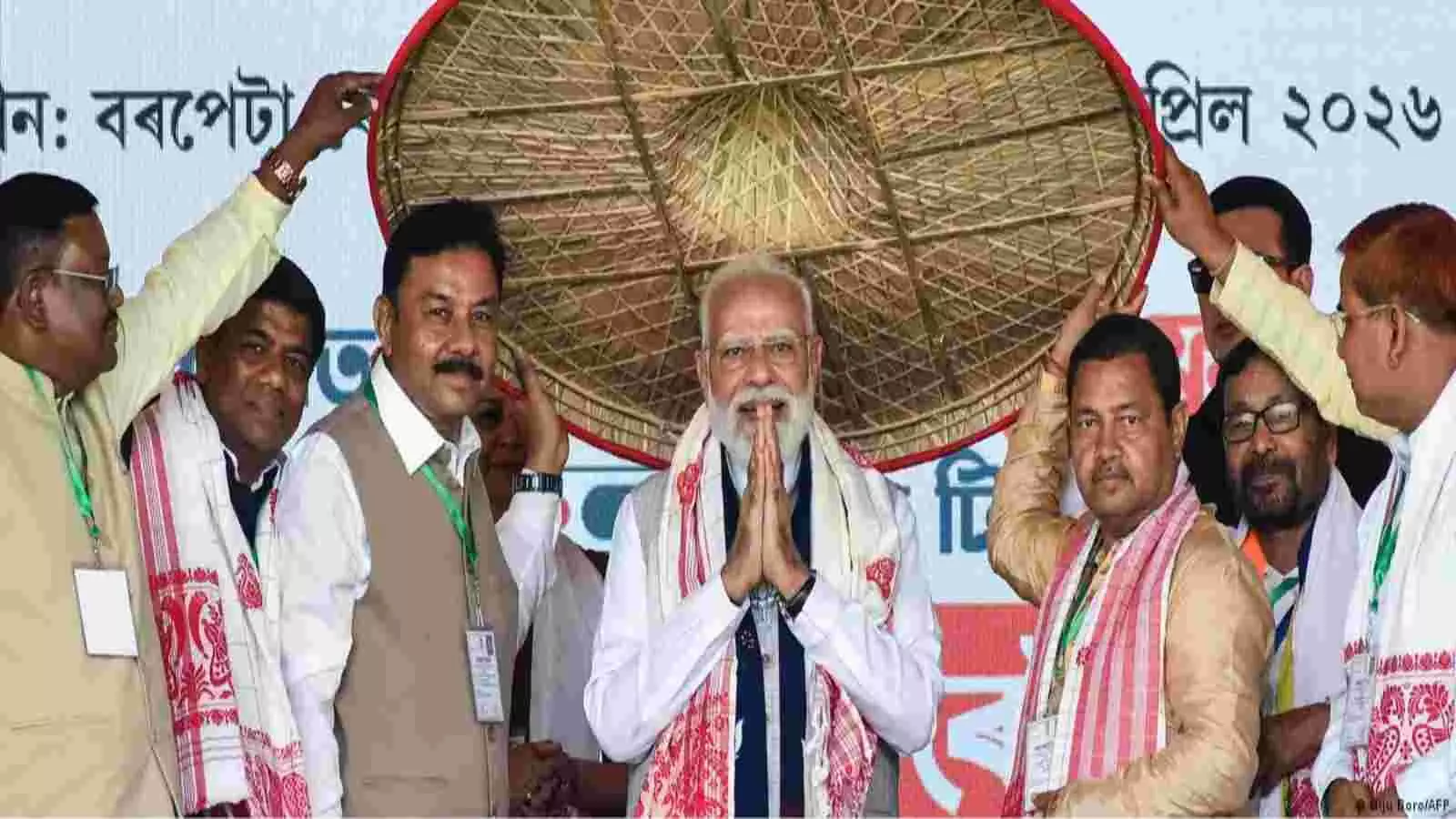 प्रधानमंत्री नरेंद्र मोदी असम में एक मंच पर पारंपरिक जापी पहनकर हाथ जोड़कर अभिवादन कर रहे हैं। प्रधानमंत्री नरेंद्र मोदी असम में एक मंच पर पारंपरिक जापी पहनकर हाथ जोड़कर अभिवादन कर रहे हैं।
