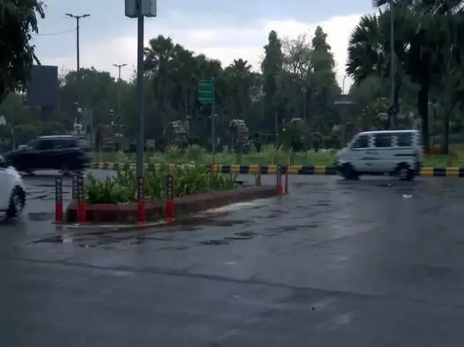 दिल्ली की सड़क पर बारिश के दौरान चलते हुए वाहन और गीली सड़क का दृश्य। दिल्ली की सड़क पर बारिश के दौरान चलते हुए वाहन और गीली सड़क का दृश्य।