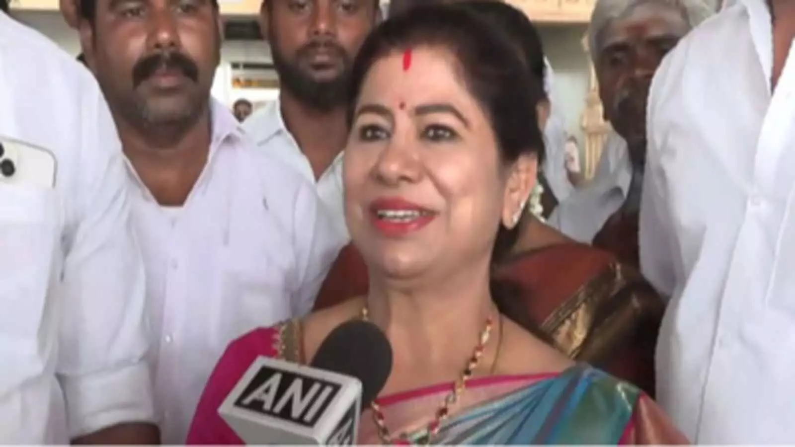 गुलाबी और नीली साड़ी पहने महिला राजनेता लीमा रोज मार्टिन सफेद शर्ट पहने समर्थकों के बीच मीडिया से बातचीत कर रही हैं। गुलाबी और नीली साड़ी पहने महिला राजनेता लीमा रोज मार्टिन सफेद शर्ट पहने समर्थकों के बीच मीडिया से बातचीत कर रही हैं।