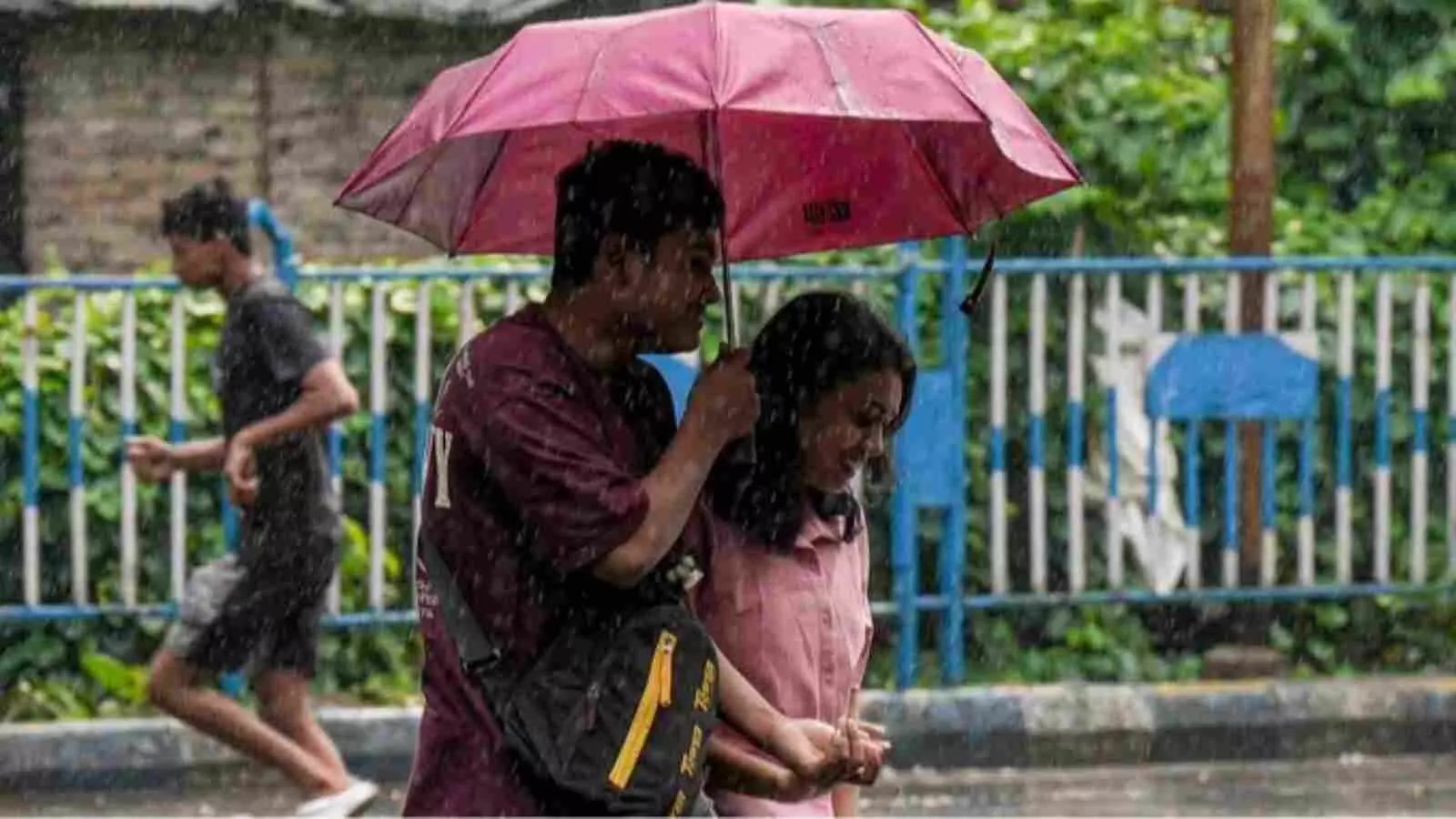 बारिश में छाता लेकर सड़क पर चलते हुए दो लोग उत्तर भारत में मौसम के बदलाव के दौरान। बारिश में छाता लेकर सड़क पर चलते हुए दो लोग उत्तर भारत में मौसम के बदलाव के दौरान।