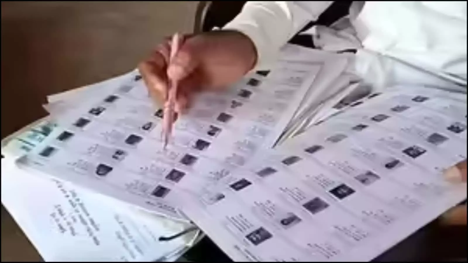 पश्चिम बंगाल में चुनाव आयोग का अधिकारी मतदान केंद्र पर मतदाता सूची के दस्तावेजों की जांच और मिलान कर रहा है। पश्चिम बंगाल में चुनाव आयोग का अधिकारी मतदान केंद्र पर मतदाता सूची के दस्तावेजों की जांच और मिलान कर रहा है।
