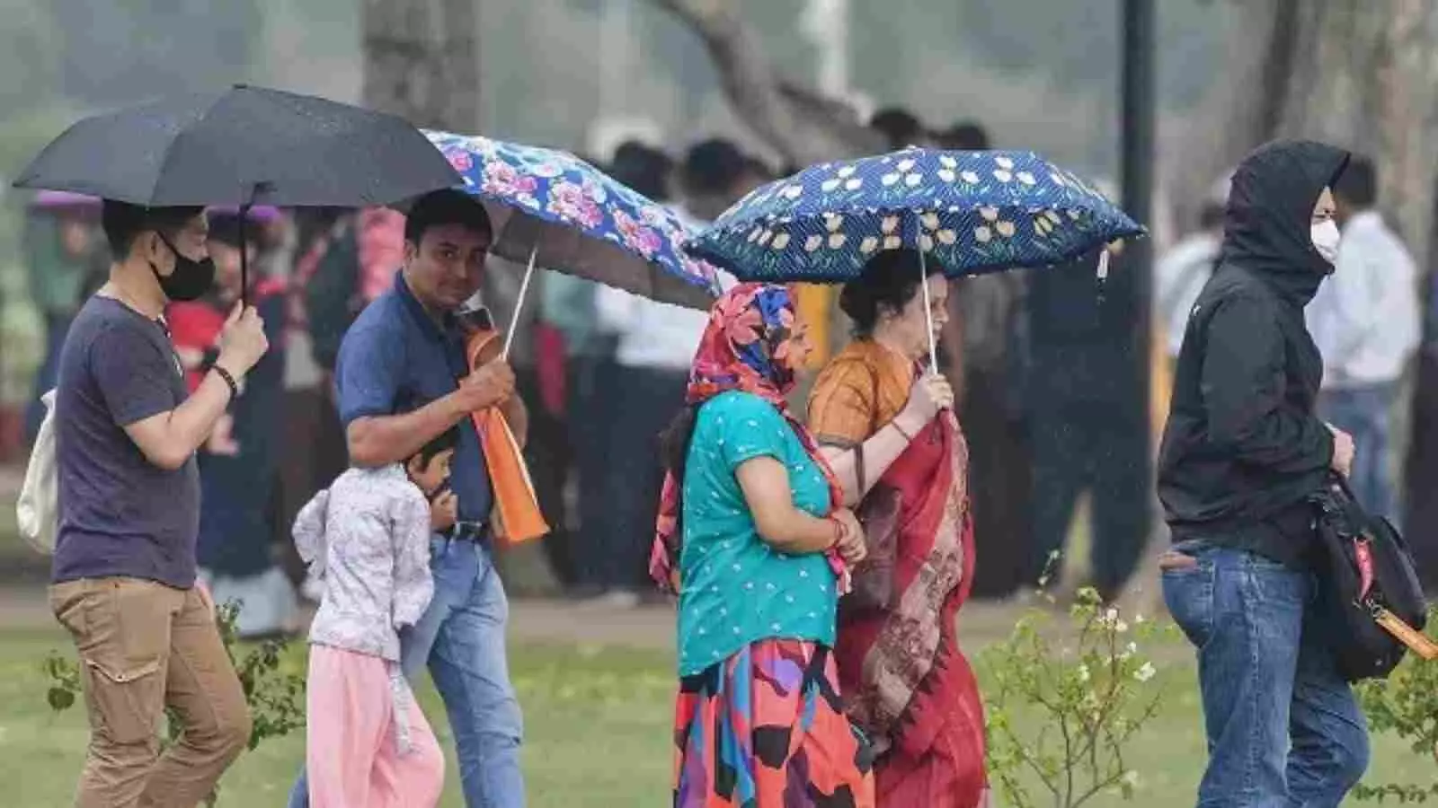 बारिश के बीच रंगीन छाते लेकर सड़क पर चलते हुए लोग दक्षिण भारत में प्री-मानसून के संदर्भ में। बारिश के बीच रंगीन छाते लेकर सड़क पर चलते हुए लोग दक्षिण भारत में प्री-मानसून के संदर्भ में।