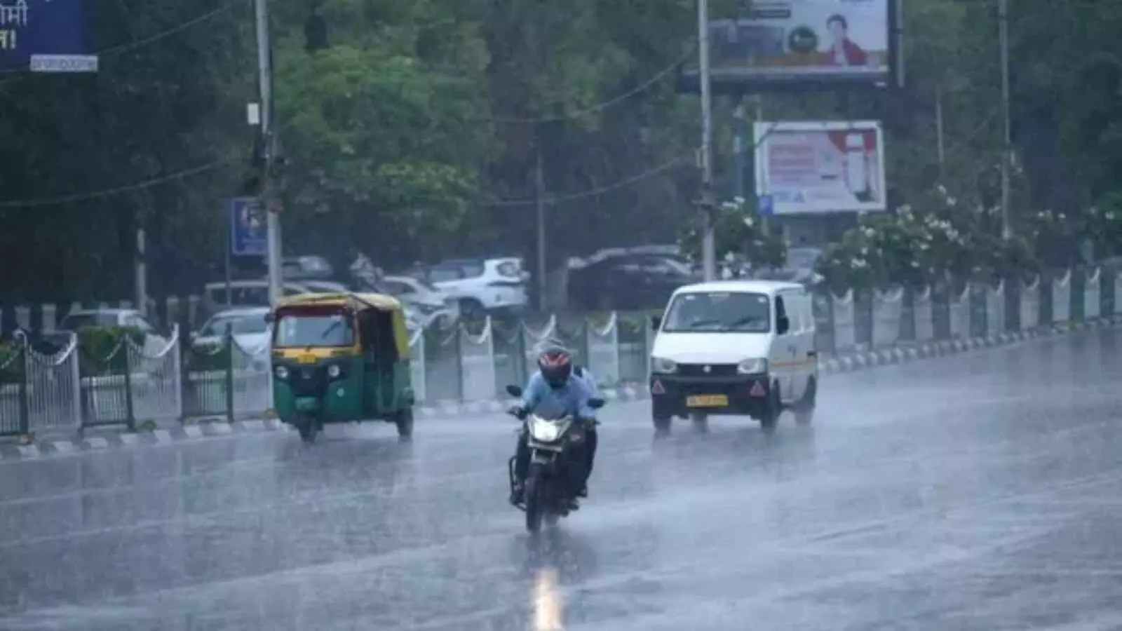 बारिश के दौरान सड़क पर चलते मोटरसाइकिल सवार और सफेद रंग की वैन उत्तर भारत के संदर्भ में। बारिश के दौरान सड़क पर चलते मोटरसाइकिल सवार और सफेद रंग की वैन उत्तर भारत के संदर्भ में।
