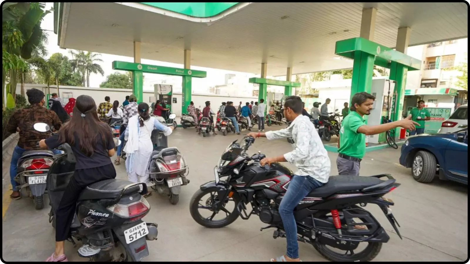 पेट्रोल पंप पर मोटरसाइकिल और स्कूटर में ईंधन भरवाते लोग भारत में तेल की कीमतों के संदर्भ में। पेट्रोल पंप पर मोटरसाइकिल और स्कूटर में ईंधन भरवाते लोग भारत में तेल की कीमतों के संदर्भ में।