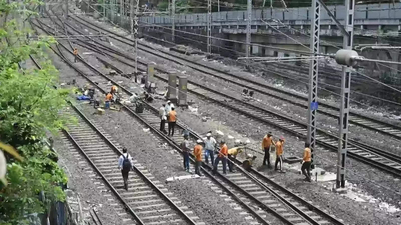 रेलवे ट्रैक पर तकनीकी कार्य के कारण खड़ी हुई ट्रेन और काम करते रेल कर्मचारी की फाइल फोटो। रेलवे ट्रैक पर तकनीकी कार्य के कारण खड़ी हुई ट्रेन और काम करते रेल कर्मचारी की फाइल फोटो।