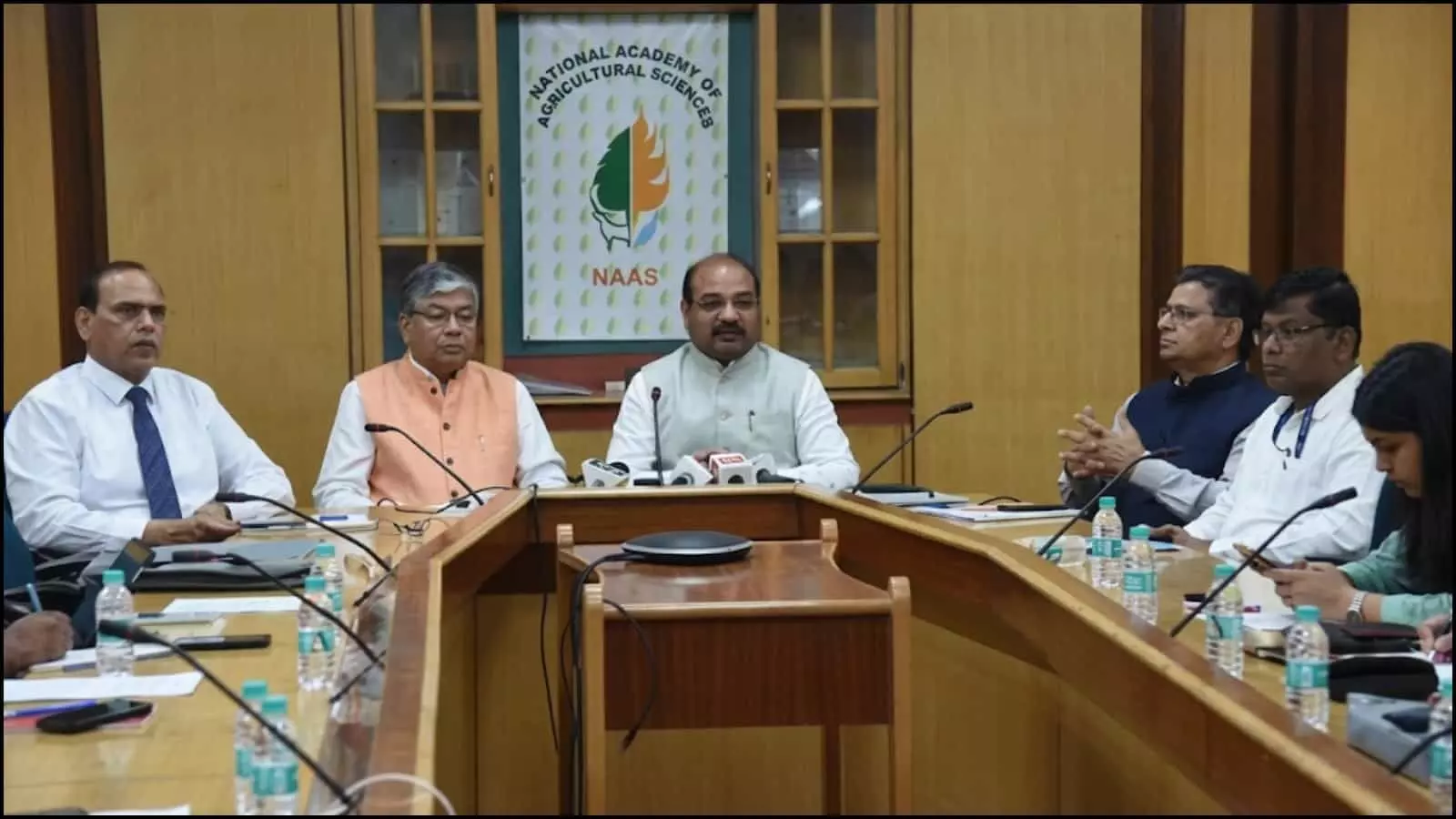 एक बैठक कक्ष में मेज के चारों ओर बैठे अधिकारी और वैज्ञानिक भारत की उर्वरक नीति पर चर्चा कर रहे हैं।