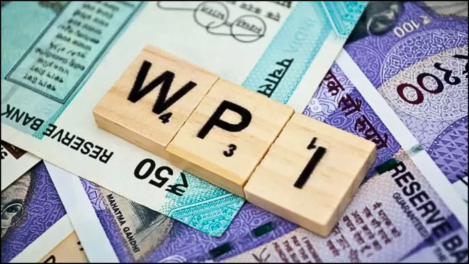विभिन्न भारतीय नोटों के ऊपर डब्ल्यूपीआई लिखे लकड़ी के तीन चौकोर ब्लॉक रखे हुए दिखाई दे रहे हैं। विभिन्न भारतीय नोटों के ऊपर डब्ल्यूपीआई लिखे लकड़ी के तीन चौकोर ब्लॉक रखे हुए दिखाई दे रहे हैं।