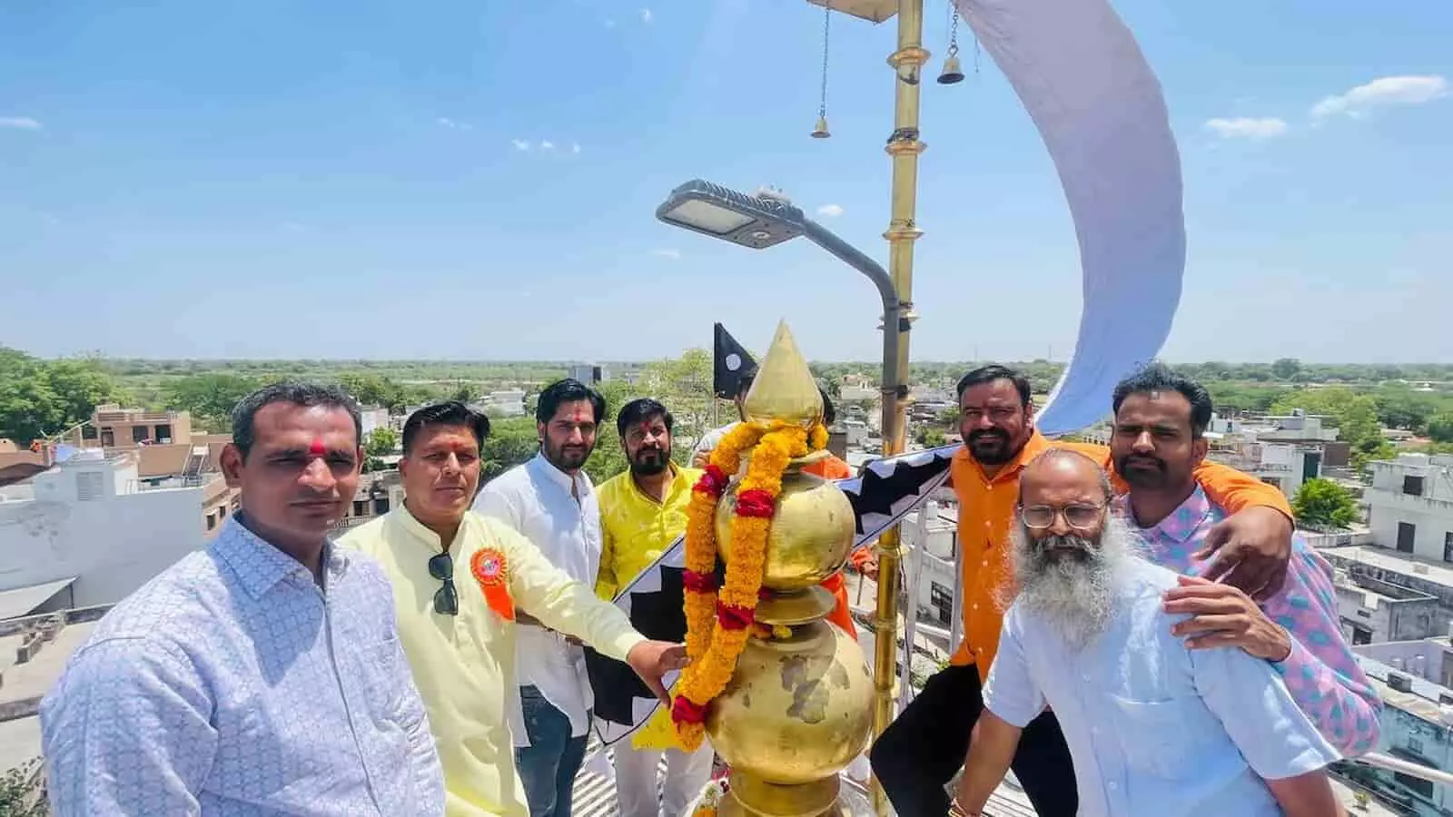 मावली के शनिधाम मंदिर में 51 फीट ऊंचे शिखर पर ध्वजा चढ़ाते हुए ग्रामीण और उपस्थित श्रद्धालु।