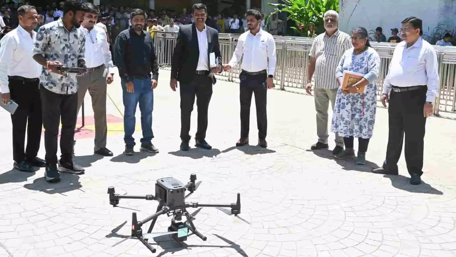 खुले मैदान में जमीन पर रखे ड्रोन के पास खड़े बीएमसी अधिकारी और विशेषज्ञ मुंबई वृक्ष गणना प्रशिक्षण के दौरान। खुले मैदान में जमीन पर रखे ड्रोन के पास खड़े बीएमसी अधिकारी और विशेषज्ञ मुंबई वृक्ष गणना प्रशिक्षण के दौरान।