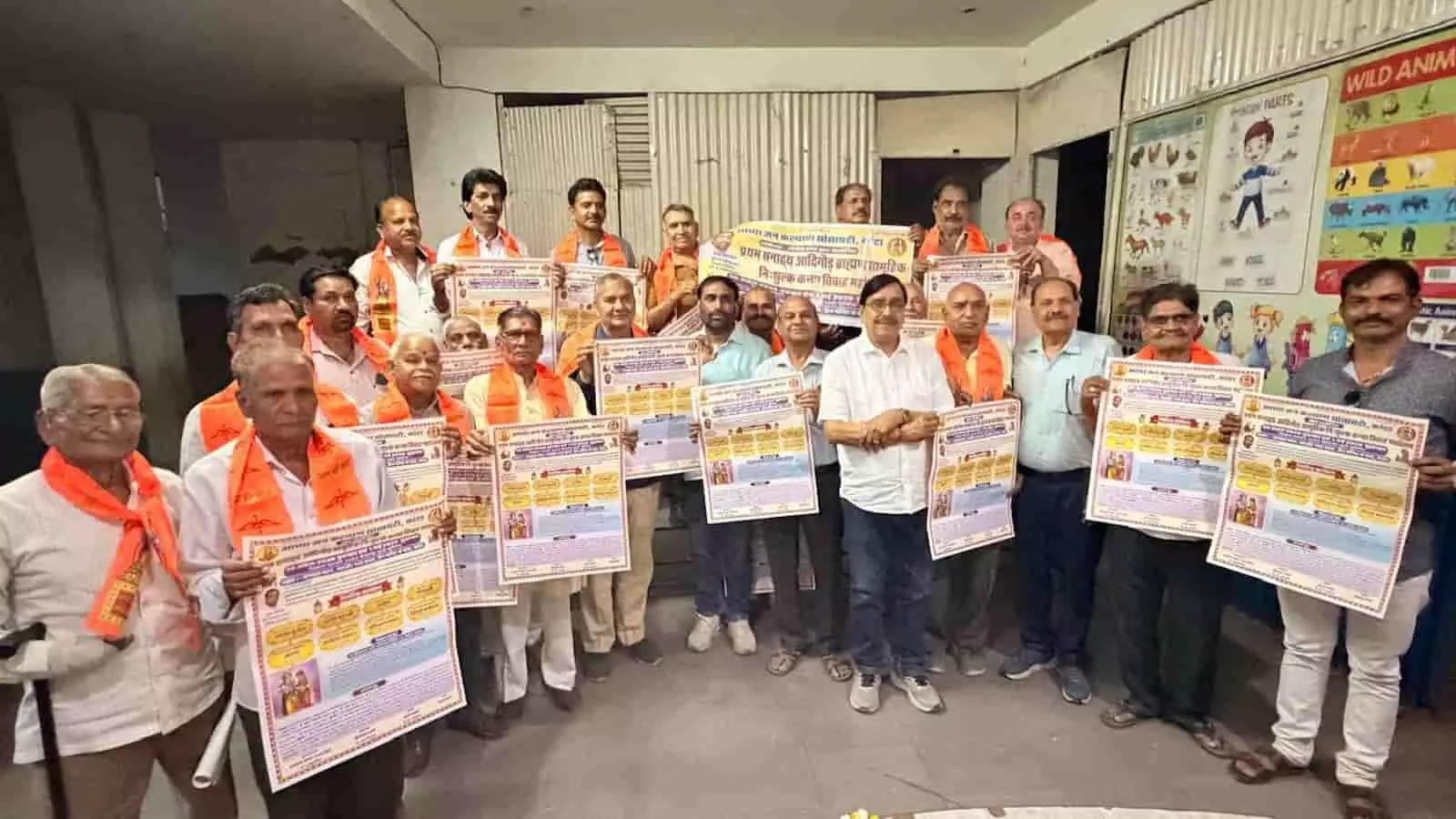 समूह में खड़े पुरुष कोटा में सामूहिक विवाह महोत्सव के पोस्टर और निमंत्रण पत्र प्रदर्शित कर रहे हैं। समूह में खड़े पुरुष कोटा में सामूहिक विवाह महोत्सव के पोस्टर और निमंत्रण पत्र प्रदर्शित कर रहे हैं।