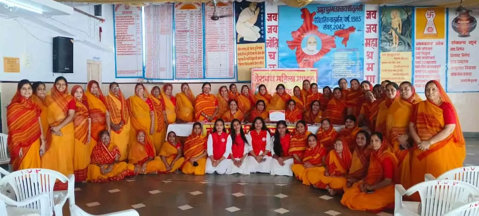 पीले और लाल रंग के परिधान में महिलाएं तेरापंथ सभा भवन आमेट में सामूहिक फोटो खिंचवा रही हैं।