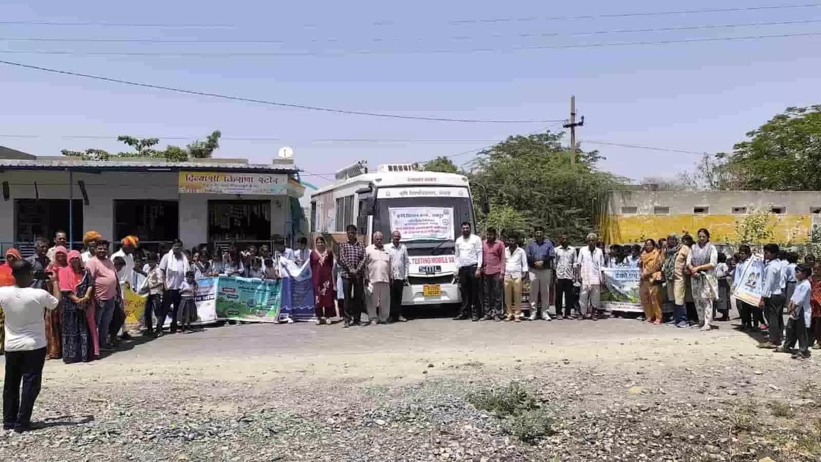 सफेद मोबाइल वैन के सामने खड़े कृषि वैज्ञानिक और ग्रामीण मिट्टी जांच अभियान के दौरान। सफेद मोबाइल वैन के सामने खड़े कृषि वैज्ञानिक और ग्रामीण मिट्टी जांच अभियान के दौरान।