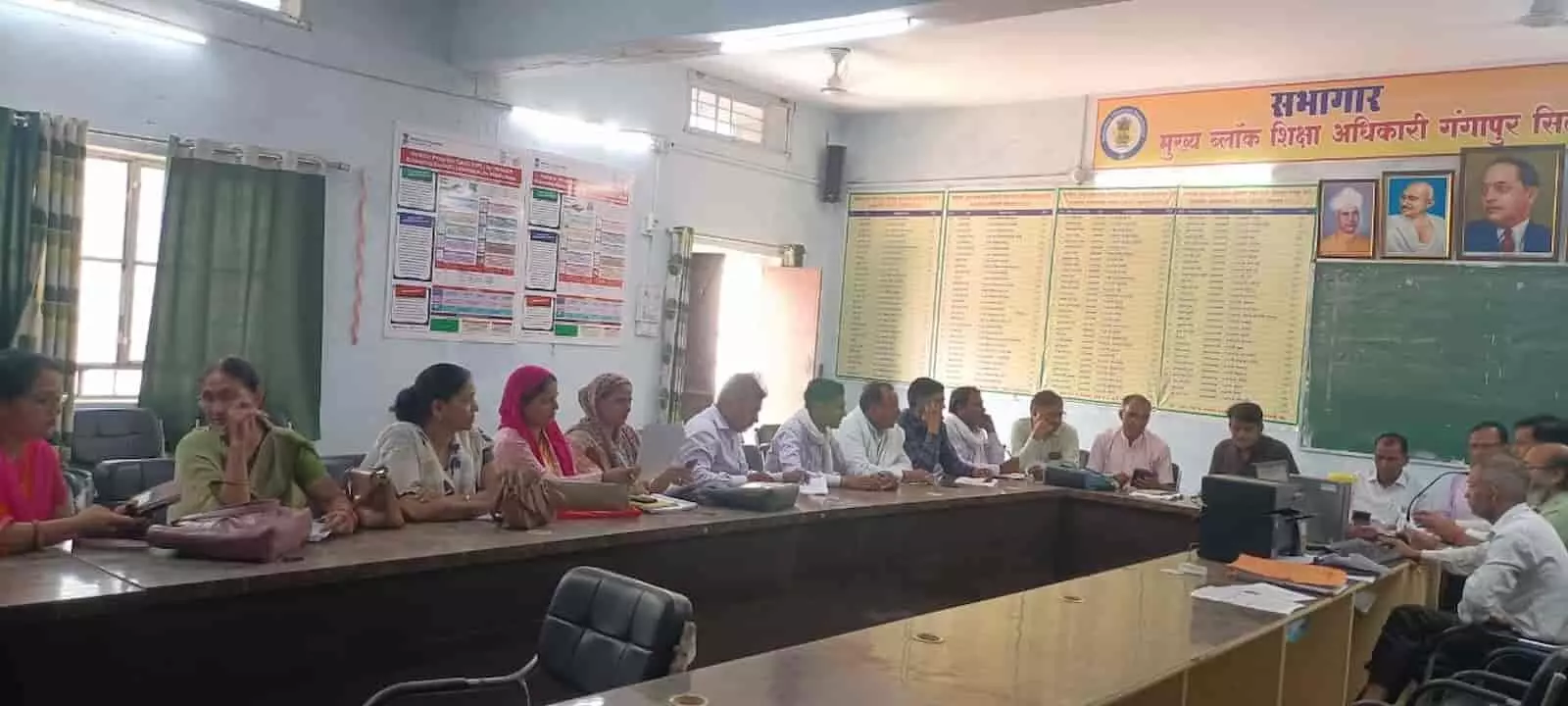 एक मेज के चारों ओर बैठे अधिकारी और महिला कार्यकर्ता ब्लॉक शिक्षा कार्यालय में बैठक करते हुए। एक मेज के चारों ओर बैठे अधिकारी और महिला कार्यकर्ता ब्लॉक शिक्षा कार्यालय में बैठक करते हुए।