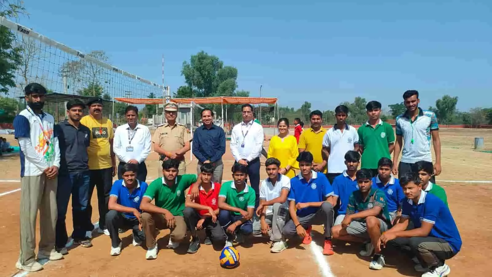खेल के मैदान में वॉलीबॉल नेट के सामने खिलाड़ियों और अतिथियों का समूह मावली नवोदय विद्यालय में।