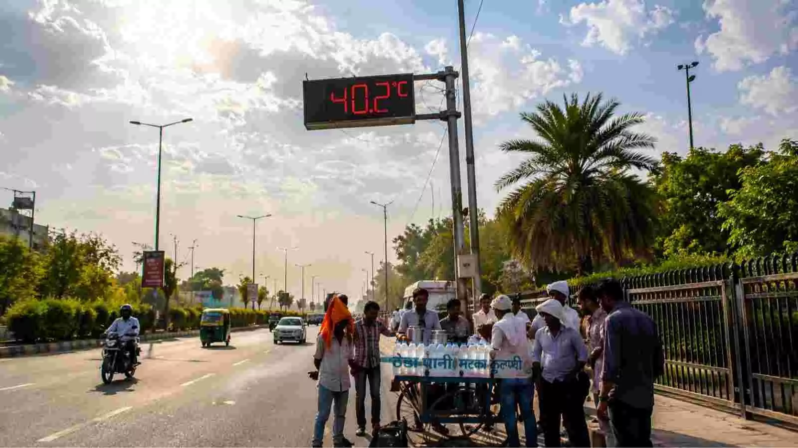 दिल्ली की सड़क पर भीषण गर्मी और तेज धूप के बीच चलते वाहन और राहगीर दिल्ली की सड़क पर भीषण गर्मी और तेज धूप के बीच चलते वाहन और राहगीर