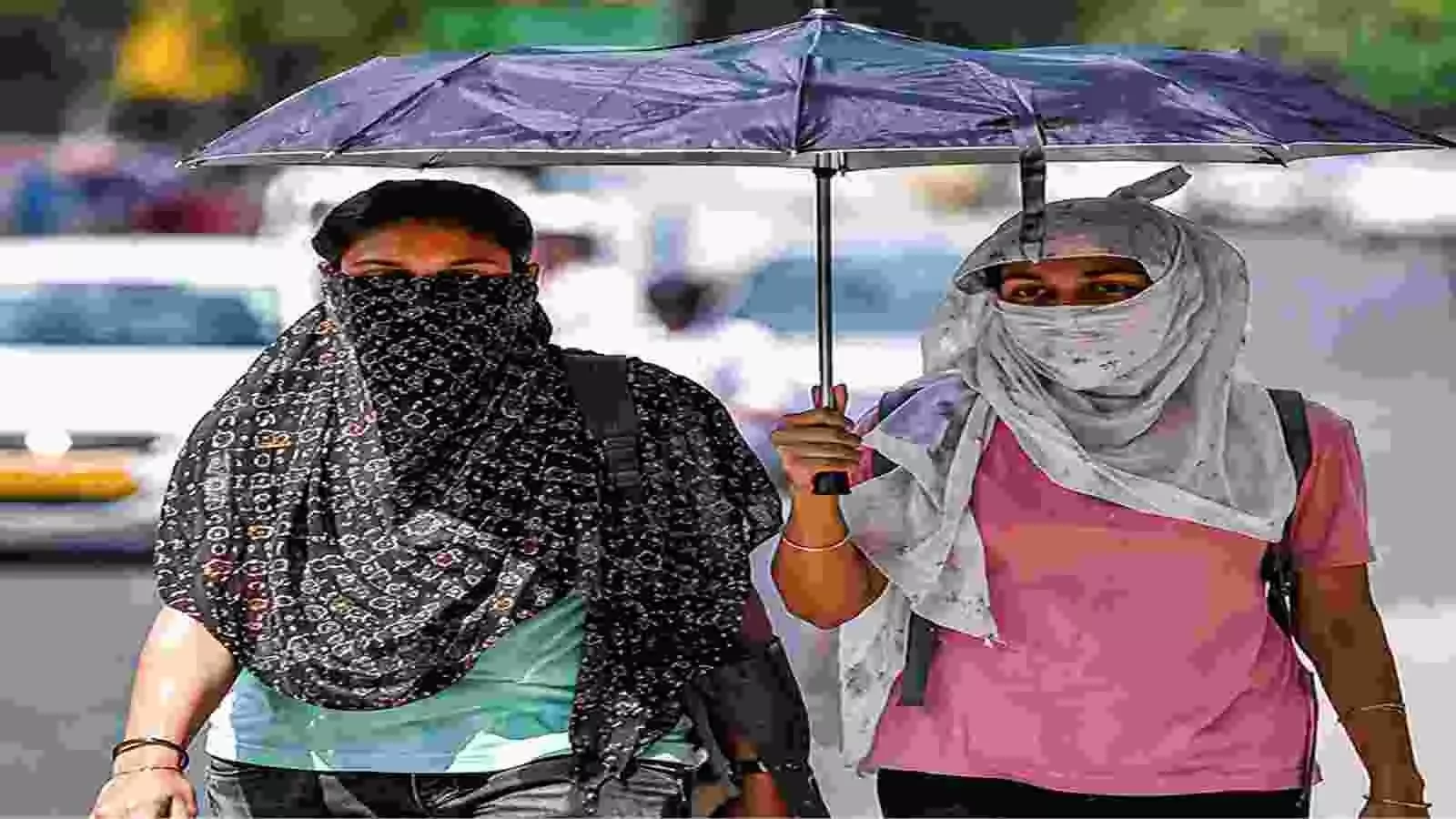 उत्तर भारत की सड़क पर तेज धूप में चेहरे को कपड़े से ढककर चलते हुए दो लोग उत्तर भारत की सड़क पर तेज धूप में चेहरे को कपड़े से ढककर चलते हुए दो लोग