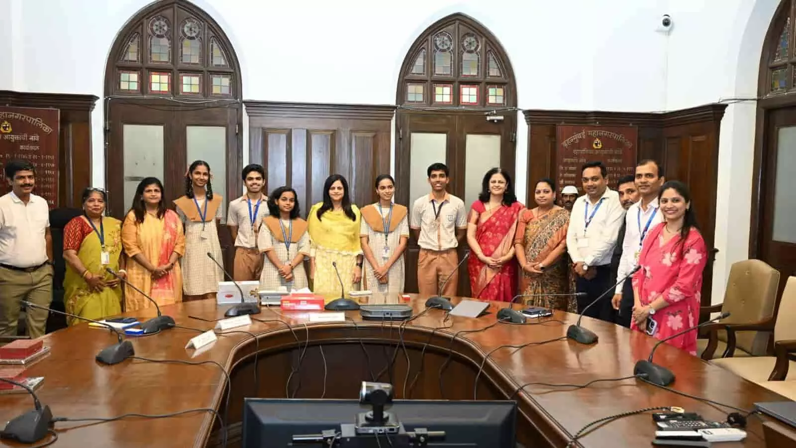 मुंबई महानगरपालिका मुख्यालय के सभागार में महापौर और आयुक्त के साथ खड़े मेधावी स्कूली छात्र।