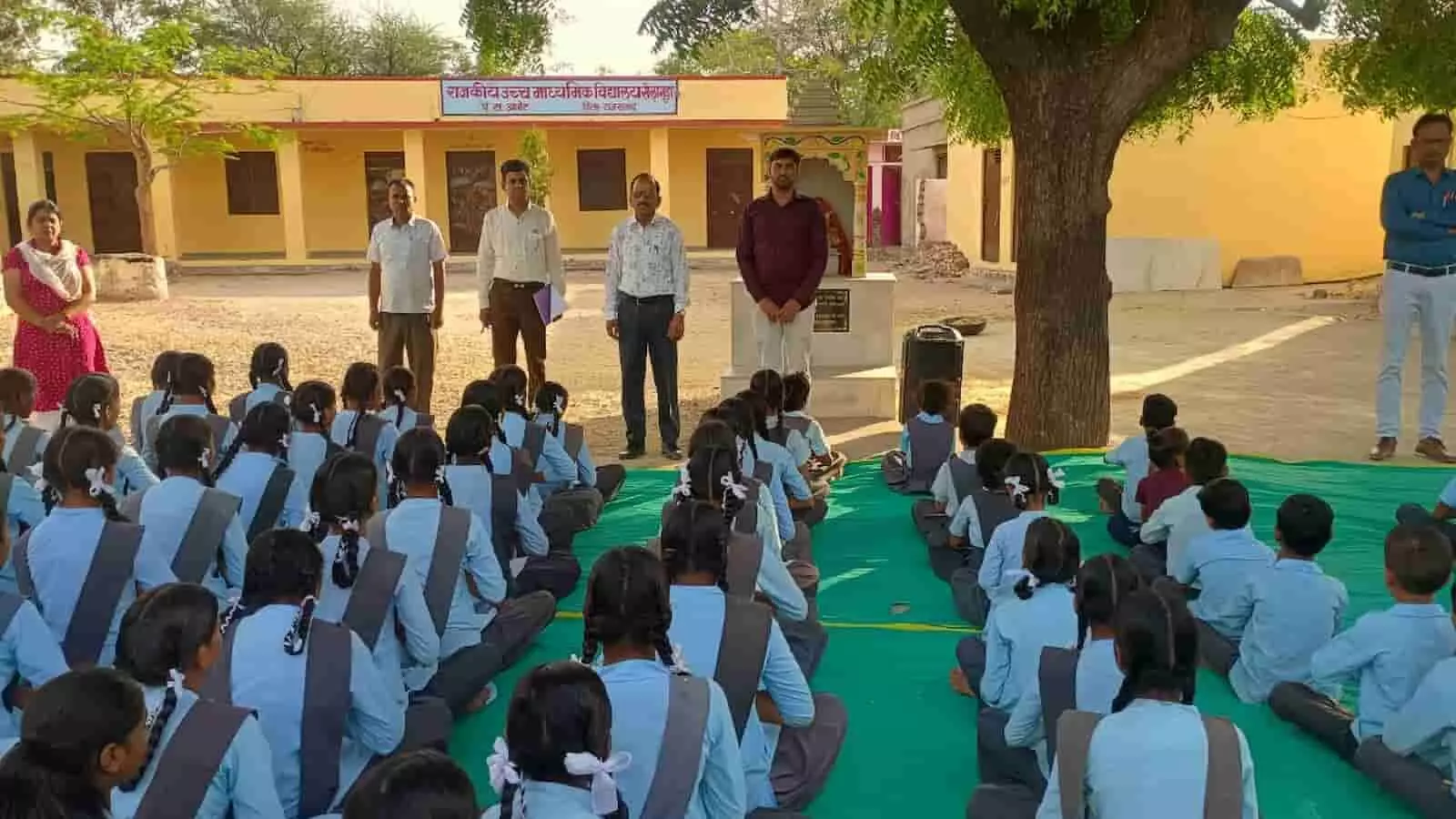 राजकीय उच्च माध्यमिक विद्यालय सेलागुड़ा के प्रांगण में प्रार्थना सभा के दौरान बैठे छात्र और निरीक्षण करते शिक्षा अधिकारी।