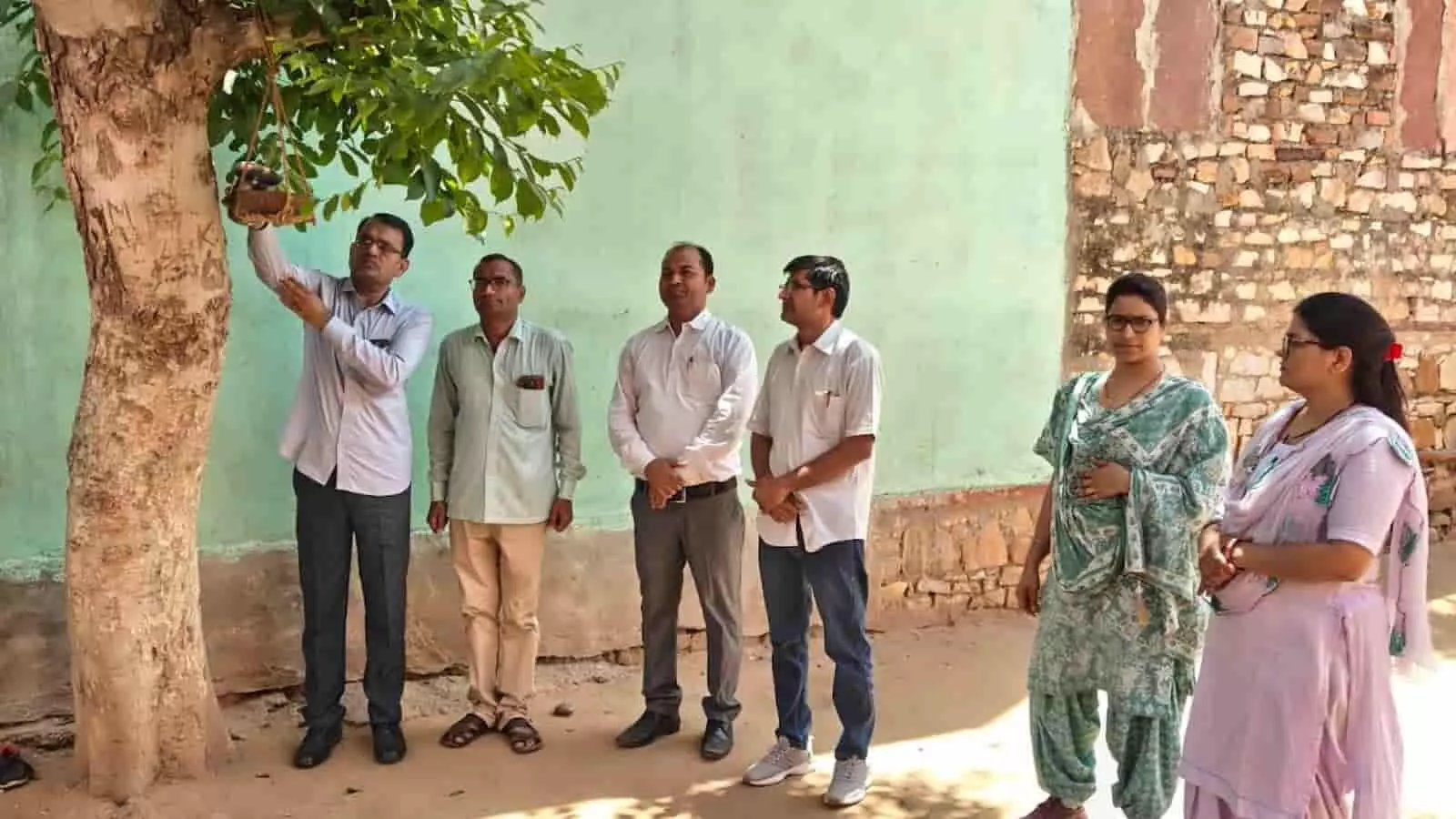 गंगापुर सिटी के विद्यालय परिसर में पेड़ पर परिंडा बांधते शिक्षक और खड़े अन्य कार्मिक। गंगापुर सिटी के विद्यालय परिसर में पेड़ पर परिंडा बांधते शिक्षक और खड़े अन्य कार्मिक।