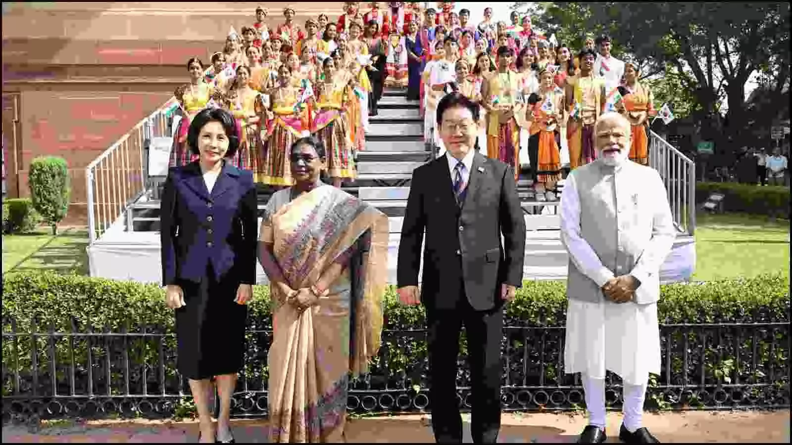 राष्ट्रपति भवन में राष्ट्रपति द्रौपदी मुर्मु, पीएम मोदी और दक्षिण कोरियाई राष्ट्रपति ली जे-म्युंग कलाकारों के साथ खड़े हैं।