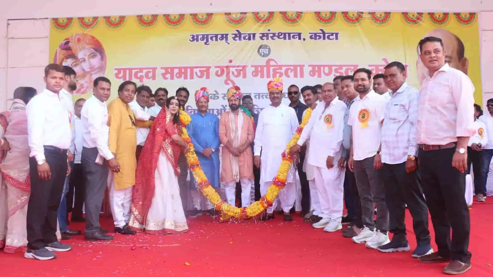 कोटा में सामूहिक विवाह सम्मेलन के दौरान मंच पर फूलों की माला पकड़े हुए अतिथि और आयोजक।