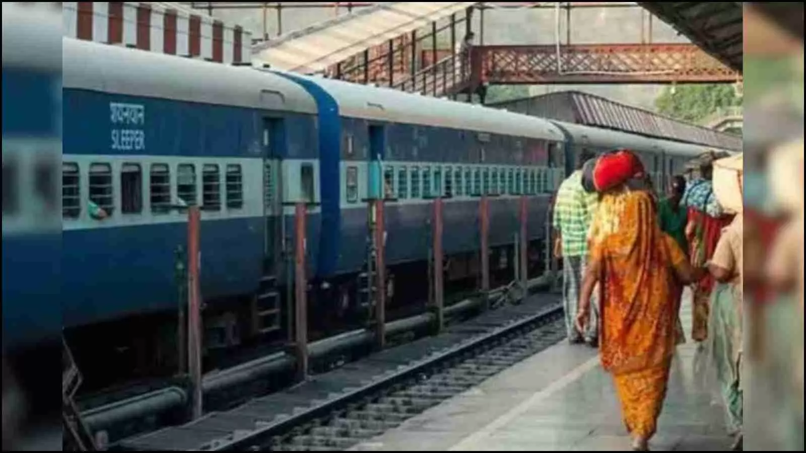 रेलवे स्टेशन के प्लेटफॉर्म पर खड़ी समर स्पेशल ट्रेन में चढ़ने के लिए कतारबद्ध होकर अपनी बारी का इंतजार करते यात्री और मुस्तैद रेलवे कर्मचारी।