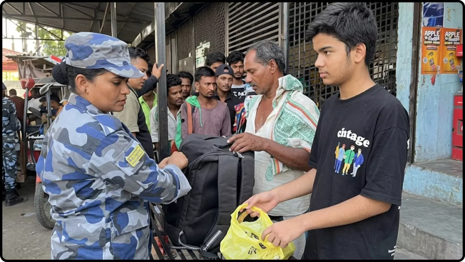 सुरक्षा वर्दी में महिला कर्मी एक युवक के सामान की जांच भारत-नेपाल सीमा पर कर रही हैं।