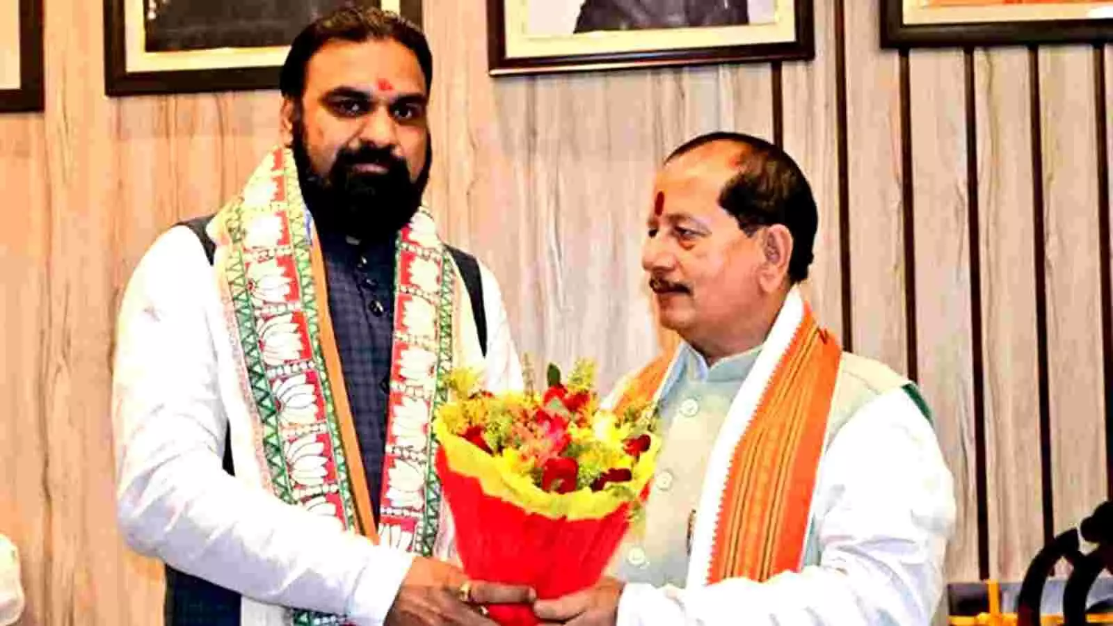 सफेद कुर्ते में सम्राट चौधरी और जैकेट पहने विजय सिन्हा पटना में बुके के साथ खड़े हैं।