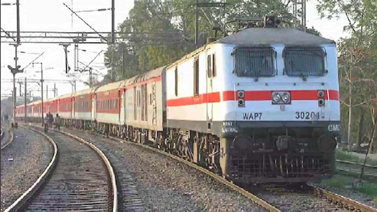 रेलवे स्टेशन के प्लेटफॉर्म पर खड़ी ट्रेन के दिव्यांग कोच में प्रवेश करते यात्री।