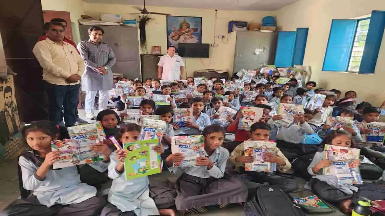 छात्र अध्ययन सामग्री पकड़े हुए कक्षा में शिक्षक और अतिथि छावा की बगीची विद्यालय कार्यक्रम में