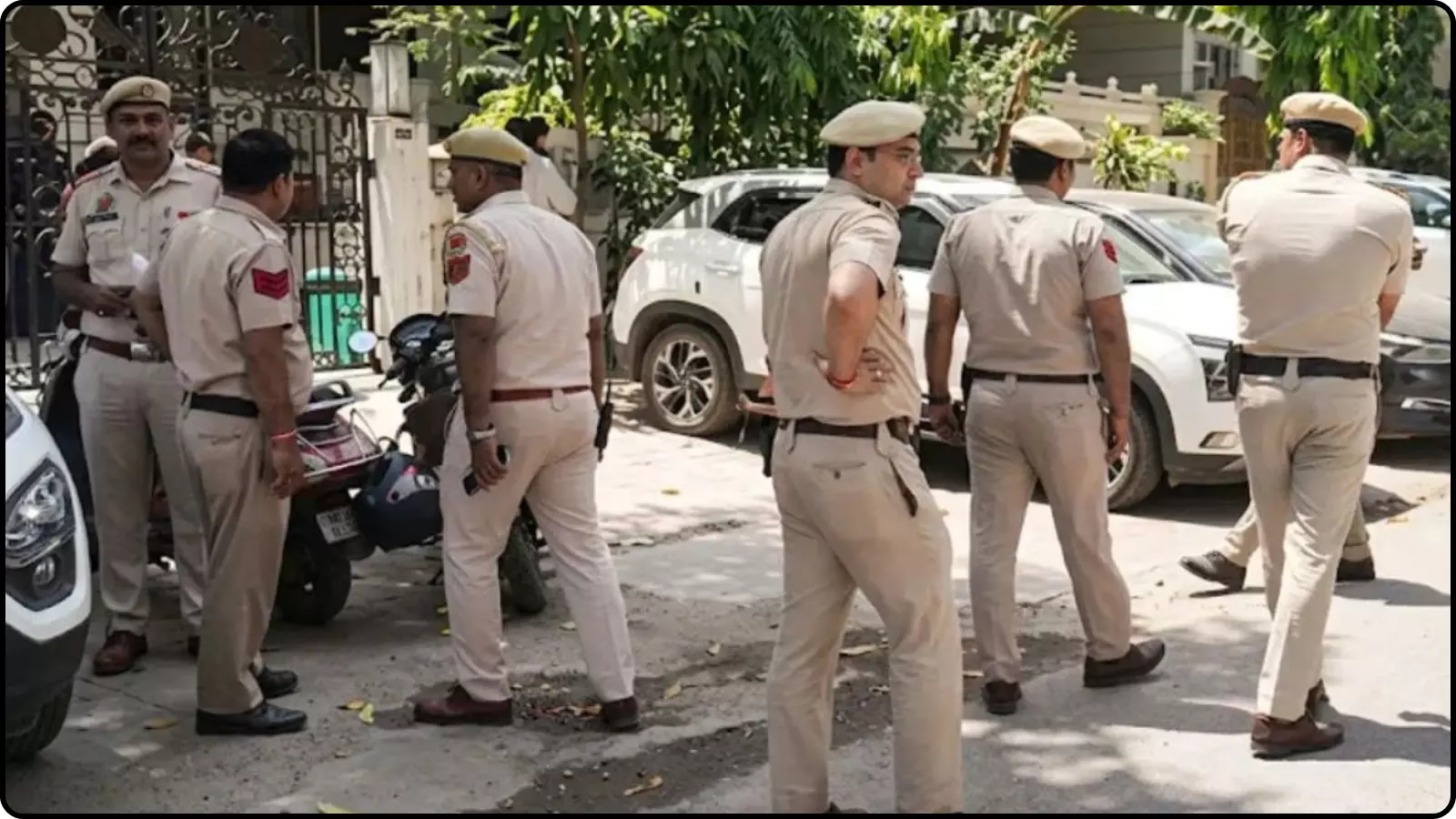 वर्दी में पुलिस कर्मी सड़क पर खड़े हैं और एक घर के बाहर जांच की जा रही है। वर्दी में पुलिस कर्मी सड़क पर खड़े हैं और एक घर के बाहर जांच की जा रही है।